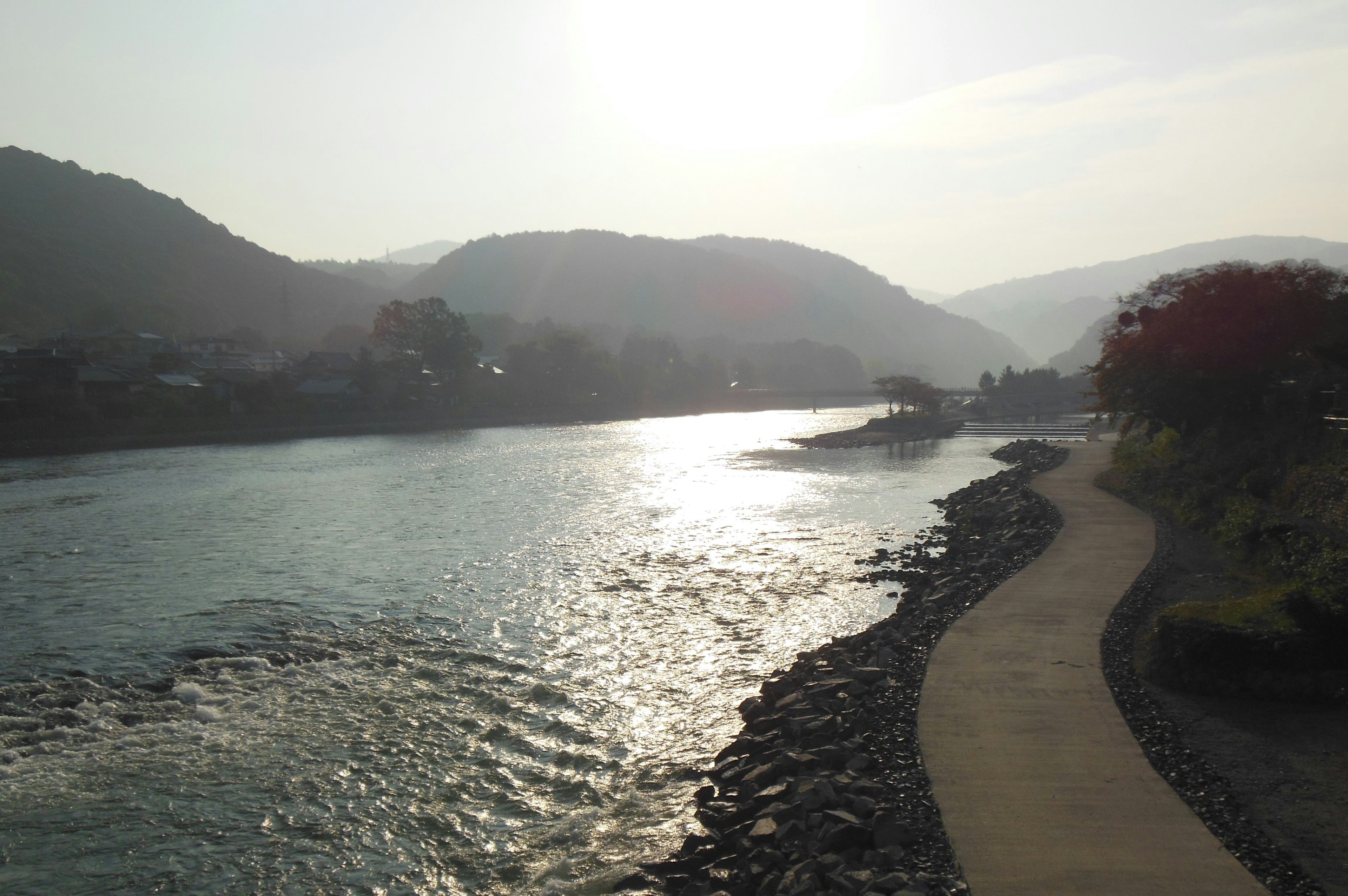 川と山の風景に朝日が差し込む静かなシーン