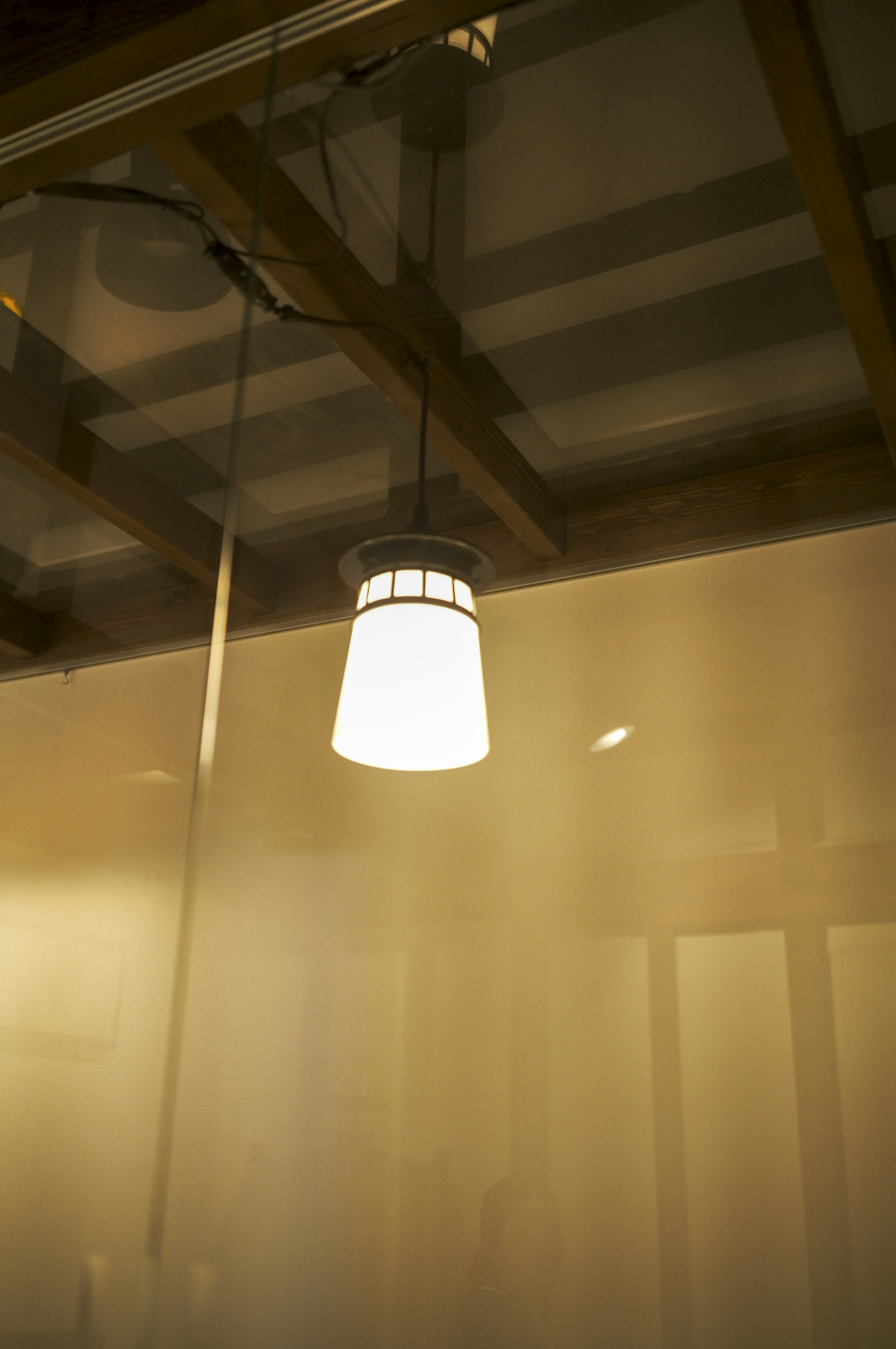 Interior of a room featuring a white hanging lamp from the ceiling