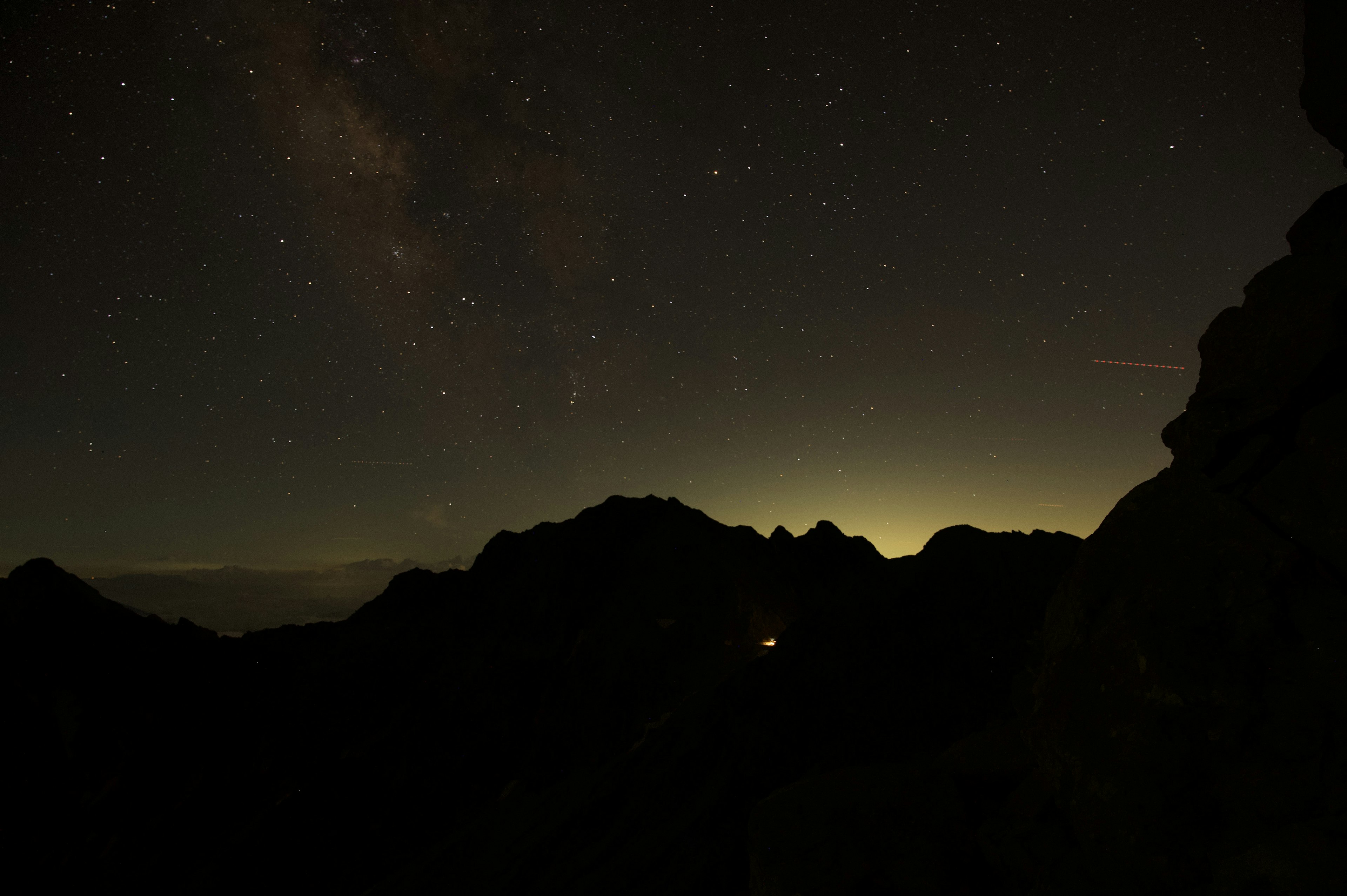 夜空に輝く星々と山のシルエットが見える風景