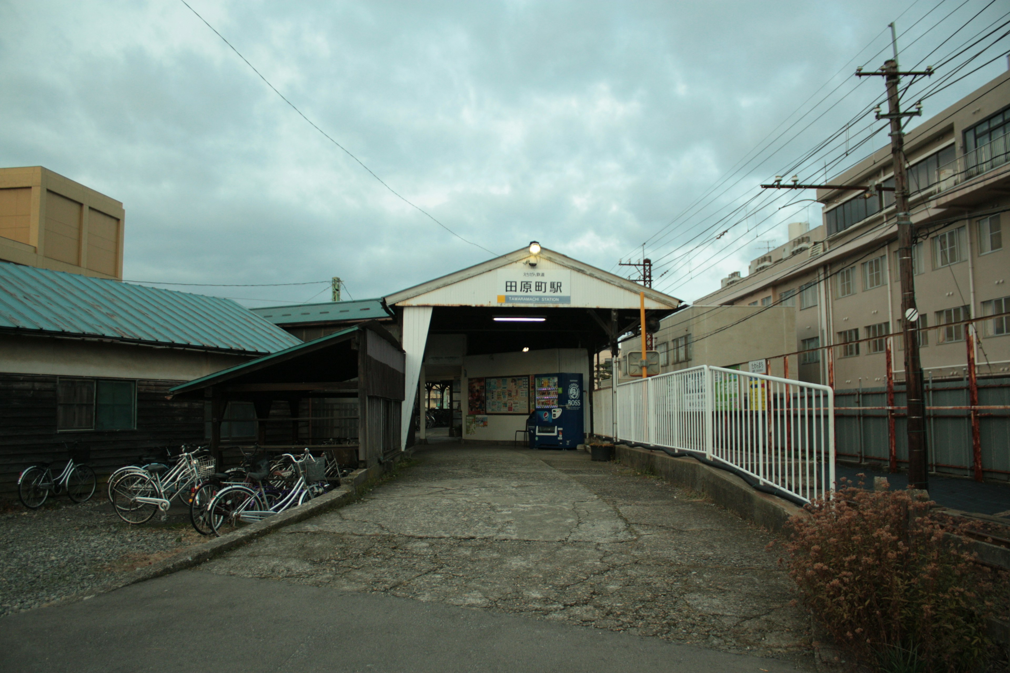 ภาพภายนอกของสถานีรถไฟพร้อมท้องฟ้าที่มีเมฆมาก