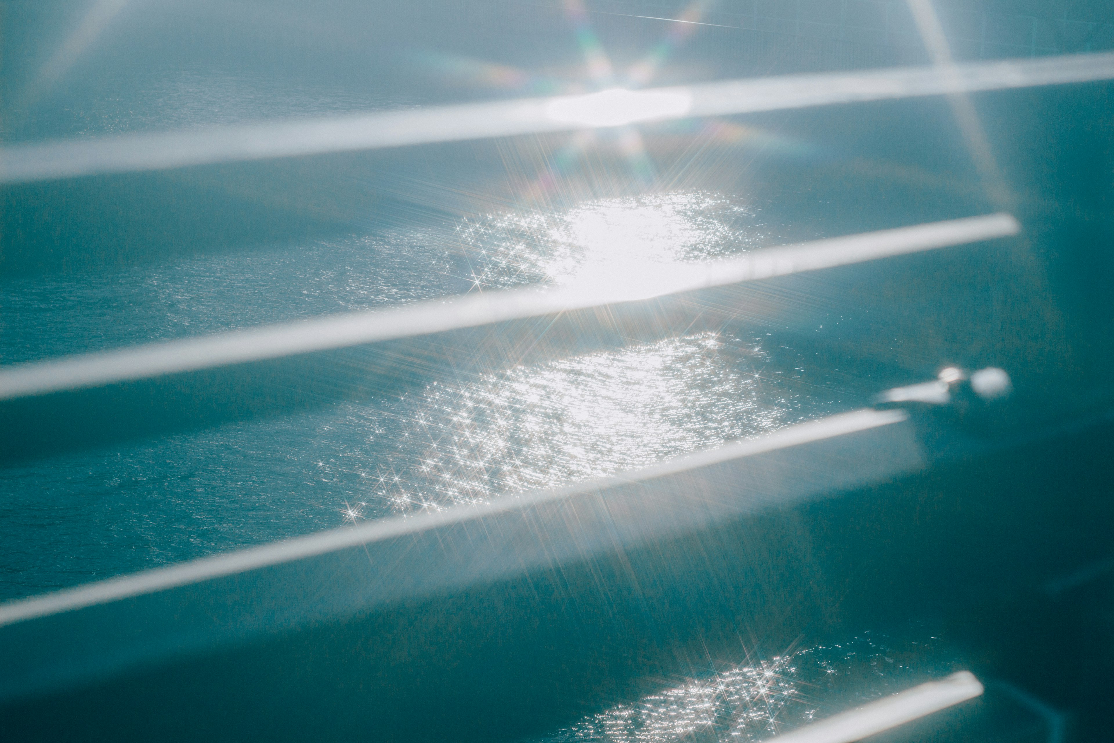 Reflections on a blue water surface with striped shadows