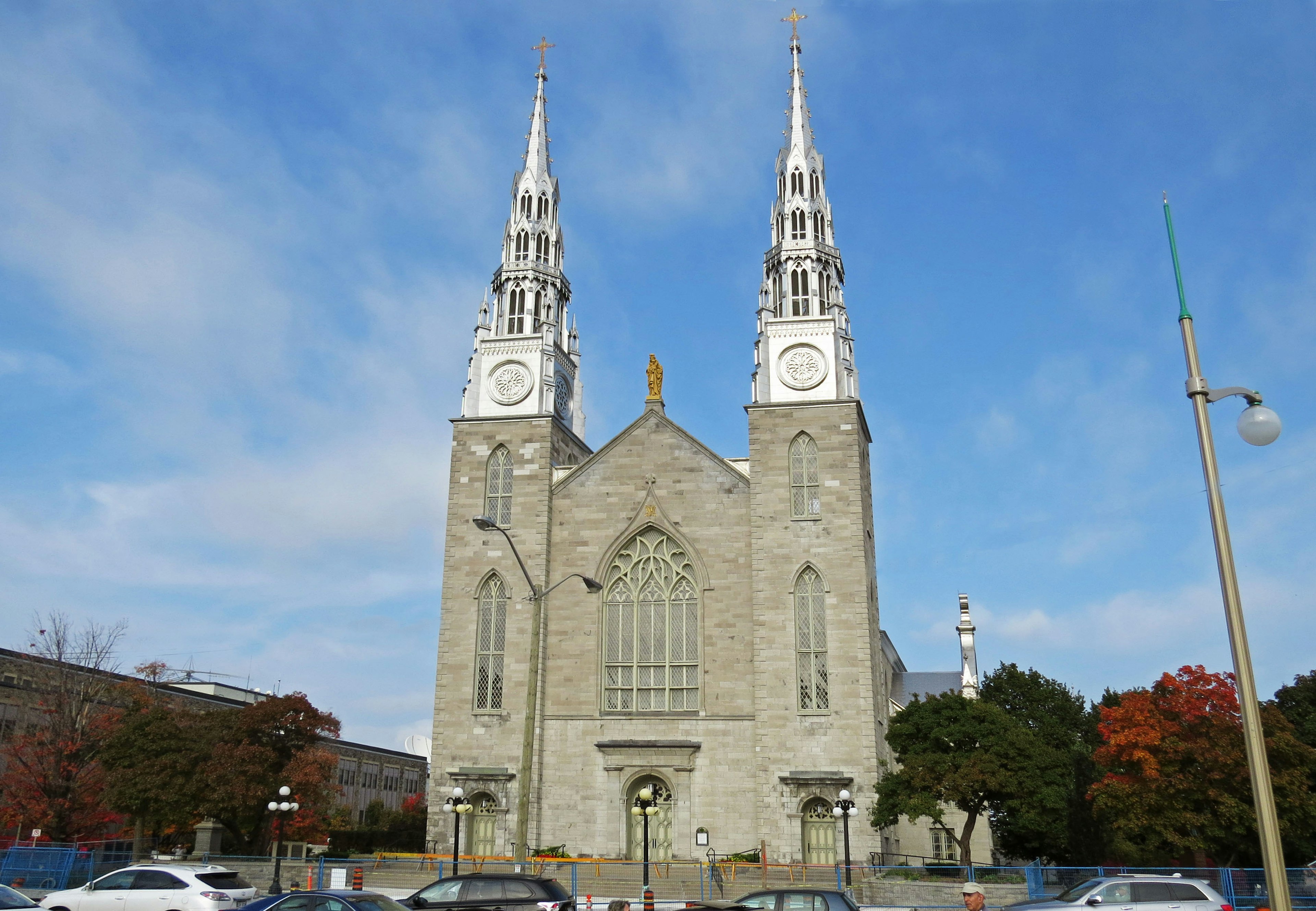 Facade of a stone church with white spires and clock towers