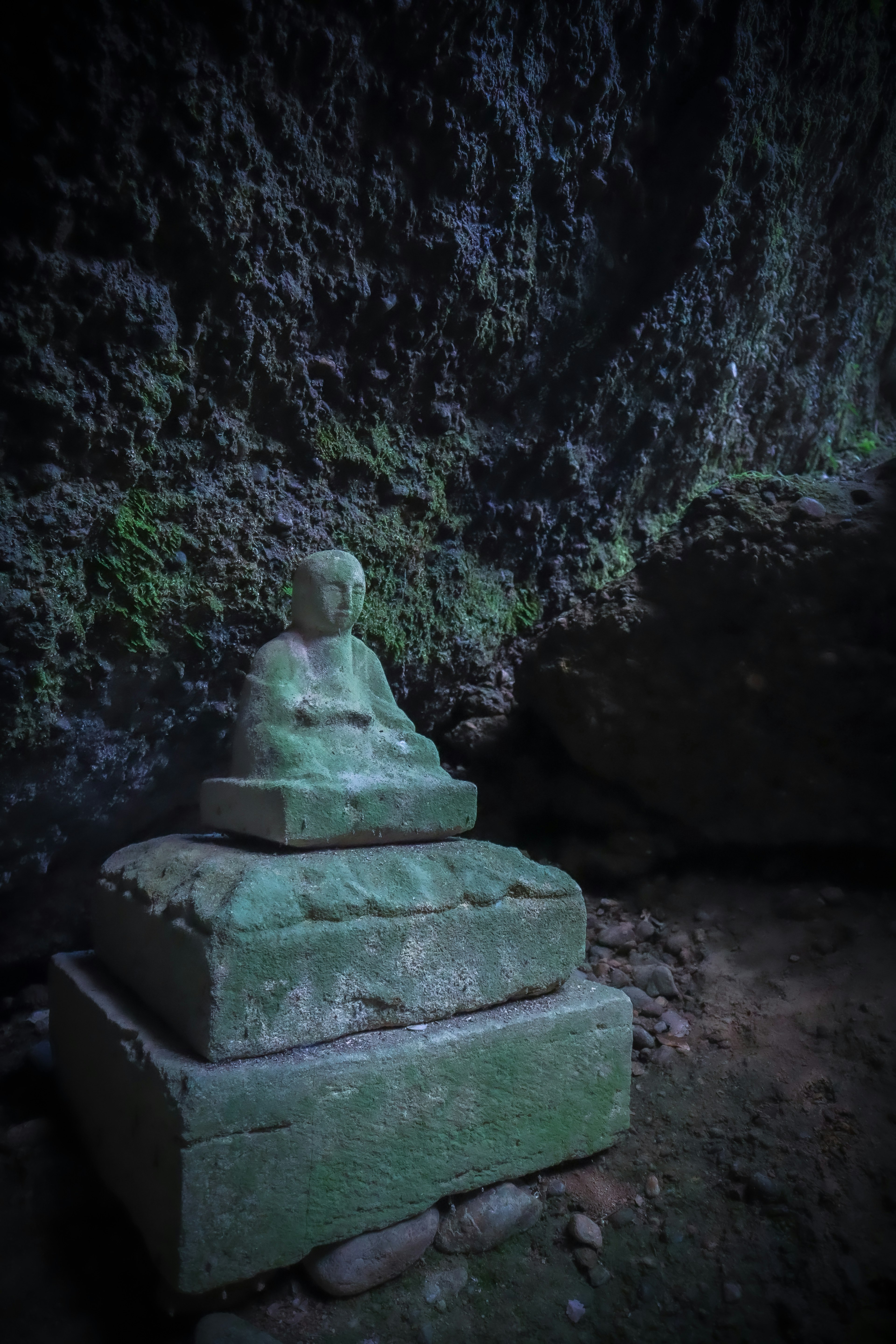 Antica statua di Buddha all'interno di una grotta Seduta su un piedistallo di pietra verde