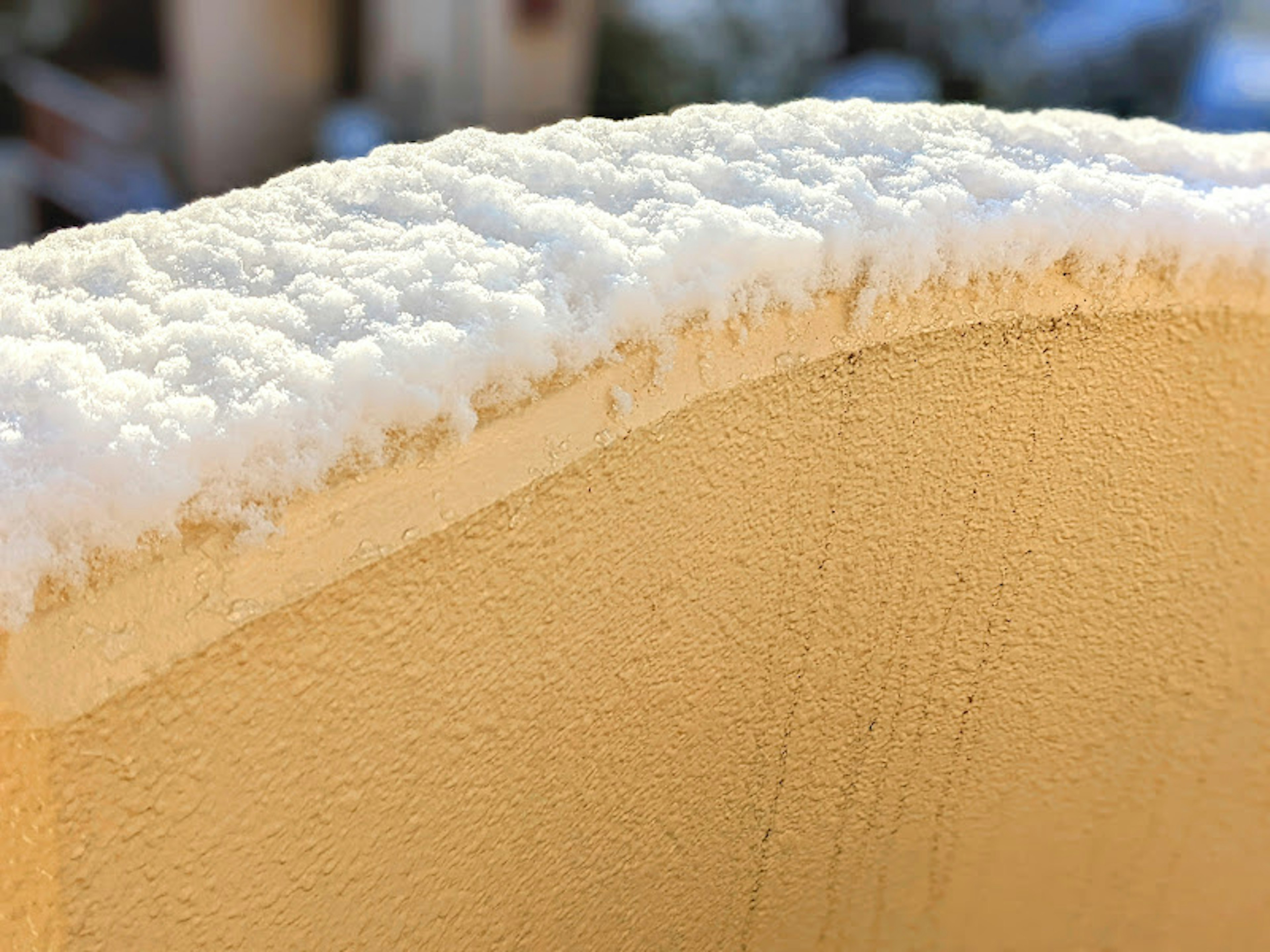 黄色表面上覆盖着雪层的特写图像