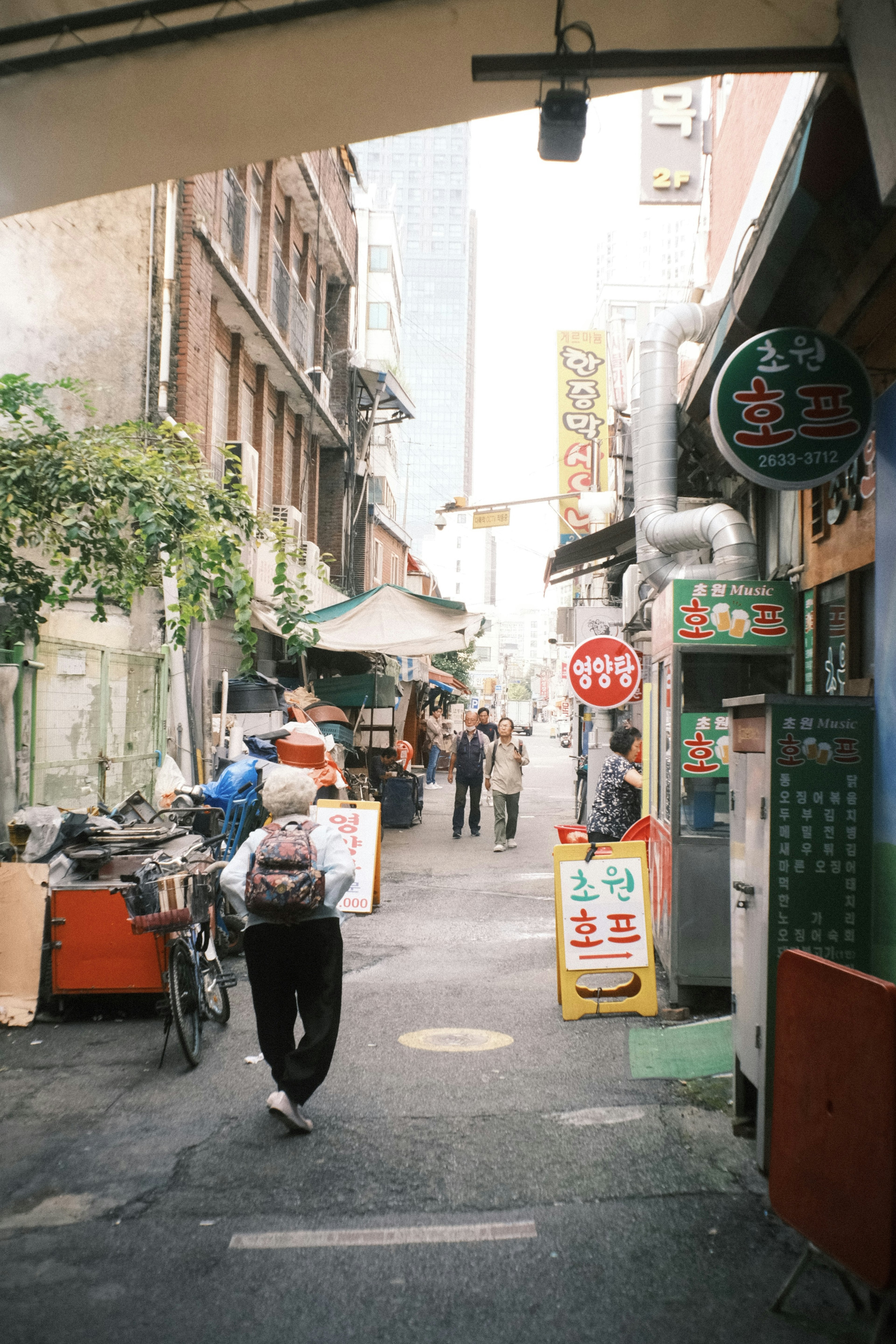 Narrow street with a person walking and vibrant shops lining the sides