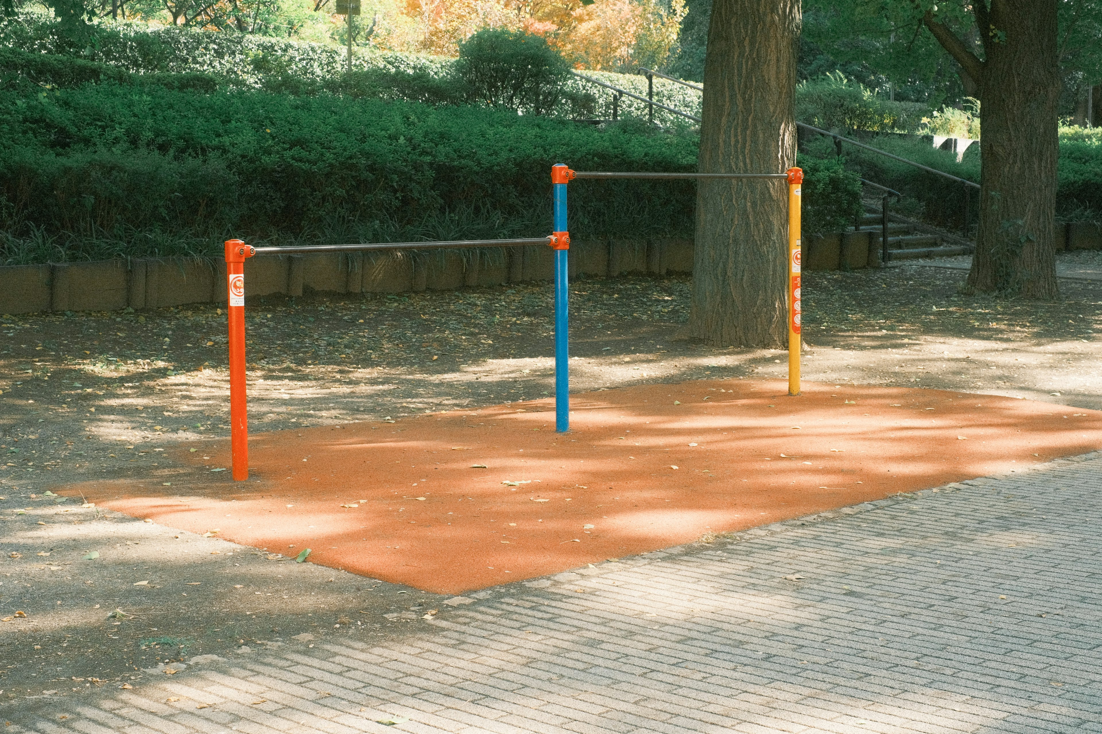 Barres bleues et orange sur une surface rouge dans un parc