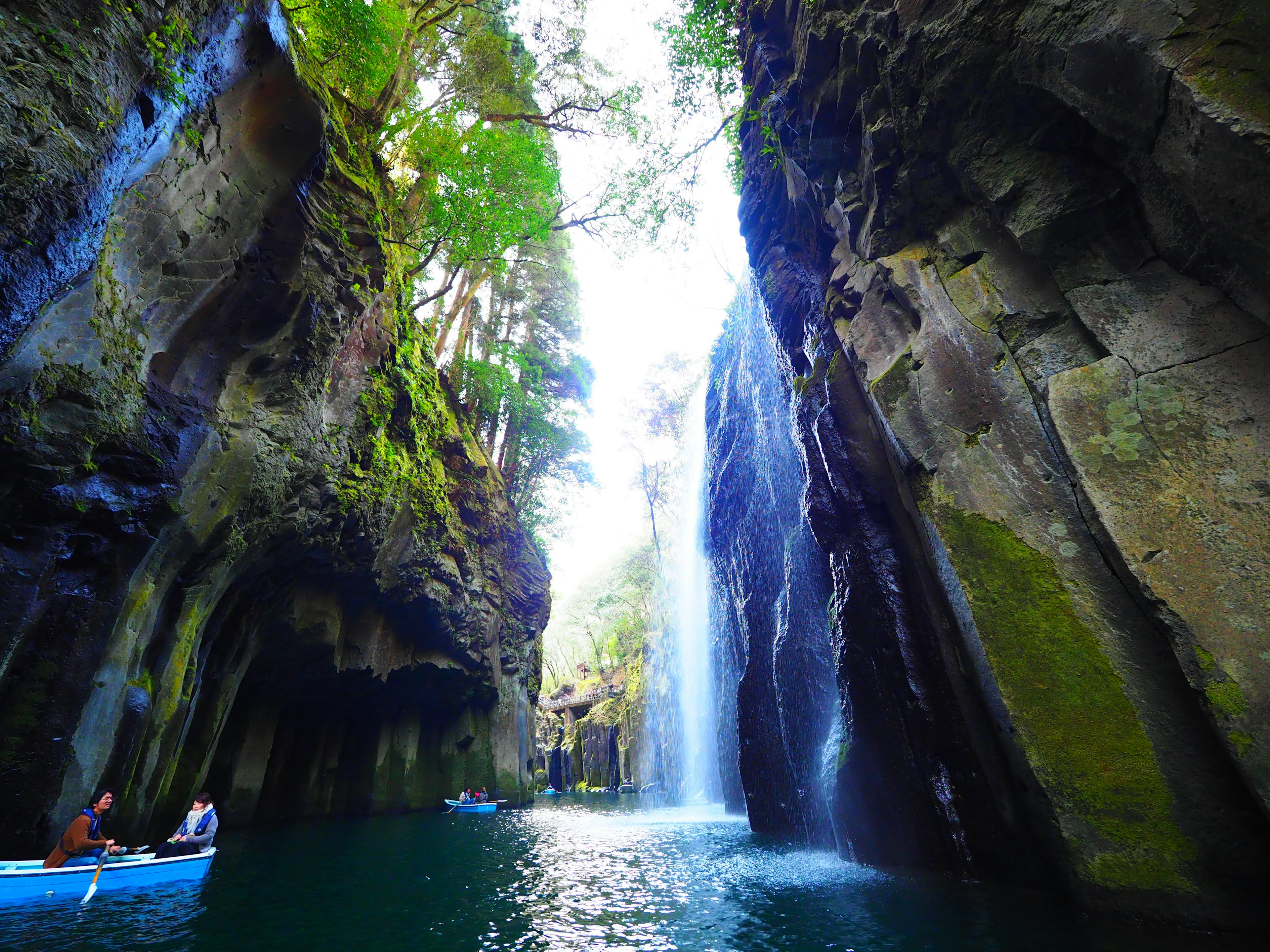 Ein ruhiger Wasserweg, umgeben von üppigen Klippen und einem schönen Wasserfall