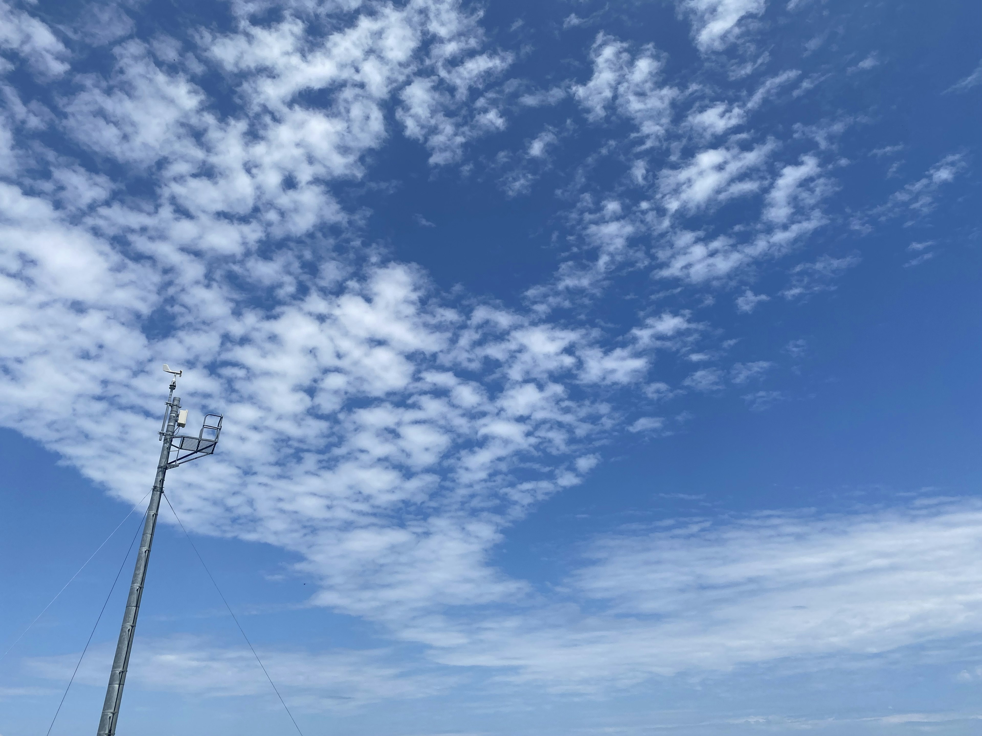 Blue sky with white clouds and a utility pole