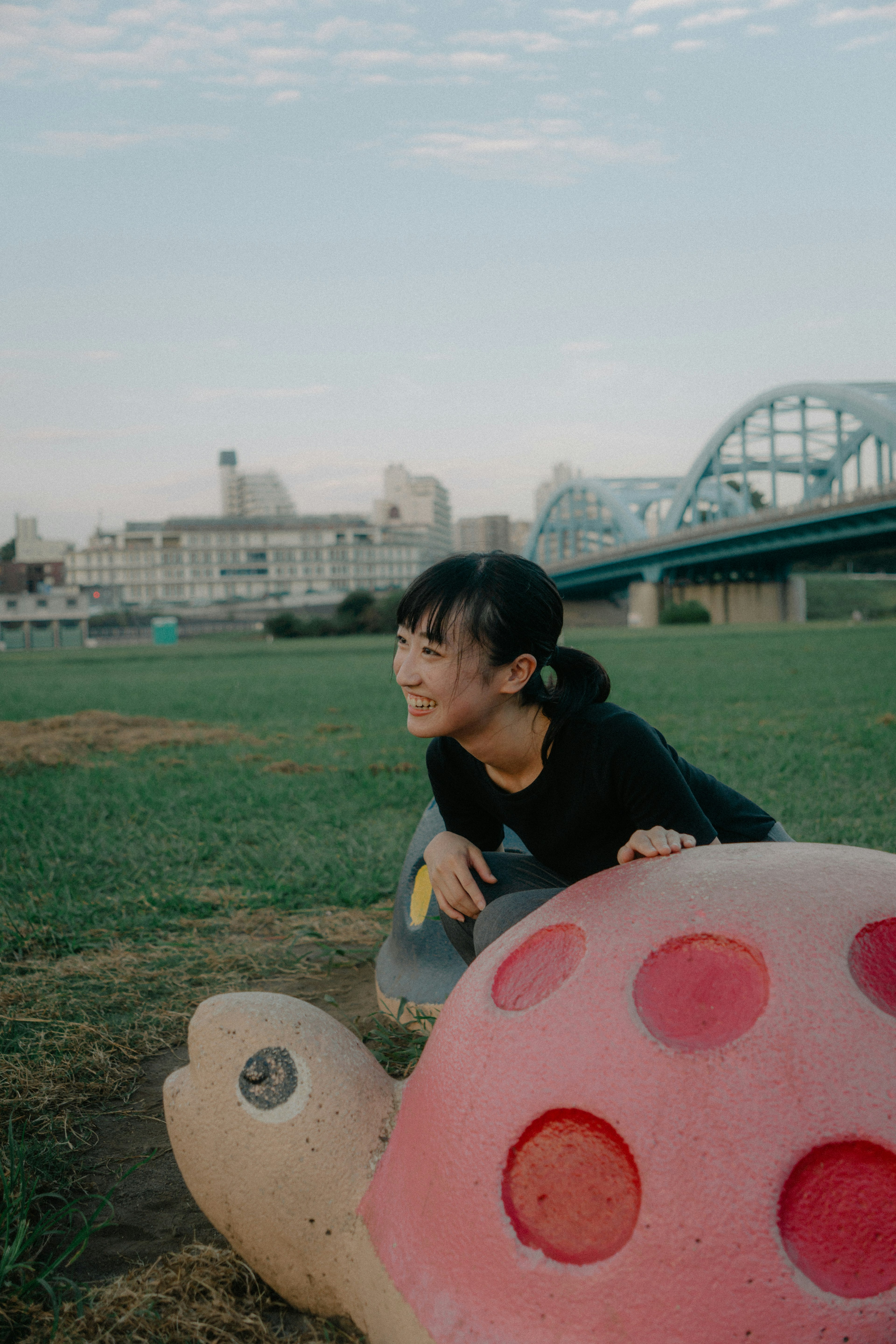 公園で遊ぶ女の子とカラフルな亀のオブジェ