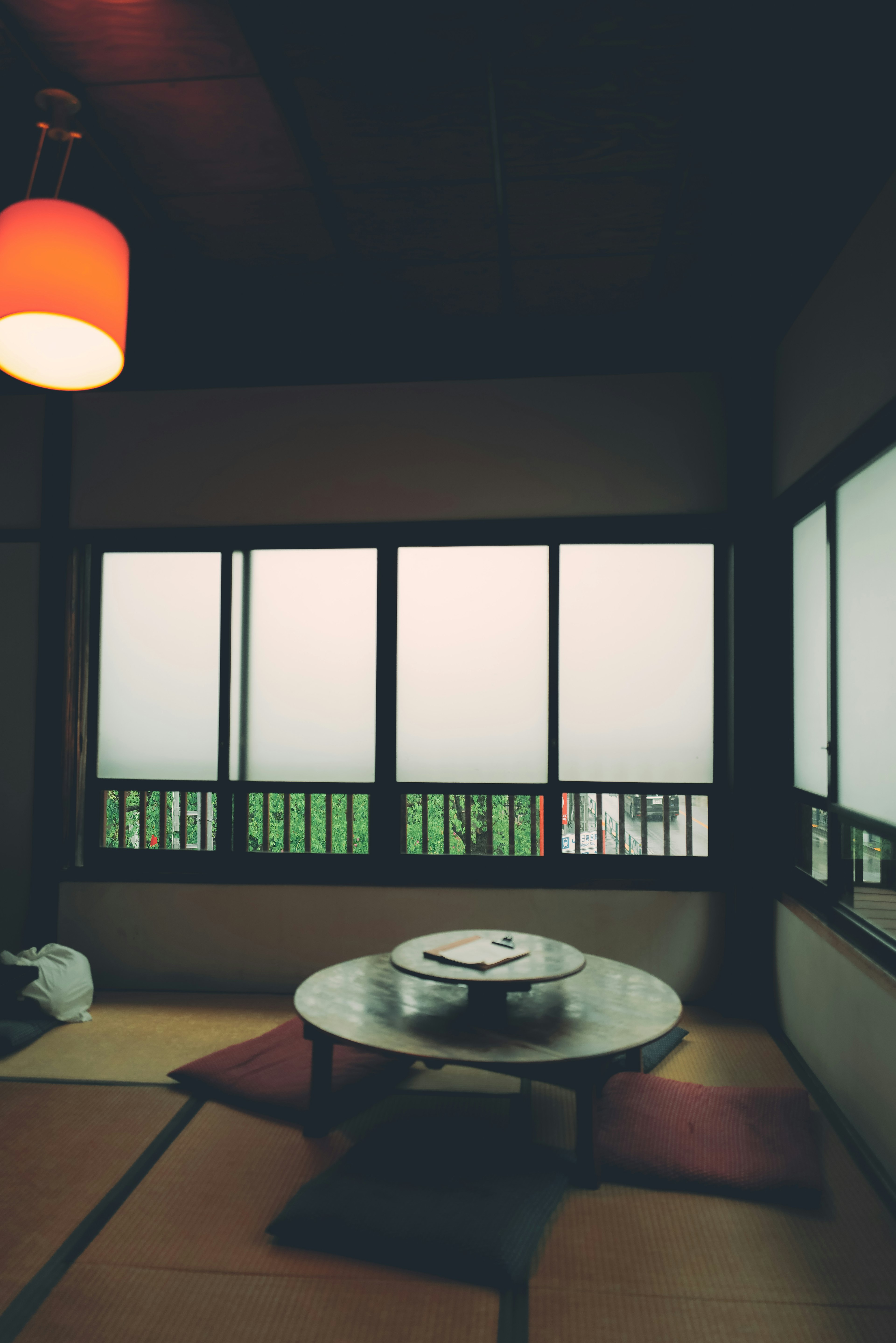 A serene Japanese room featuring a low table and large windows with a view