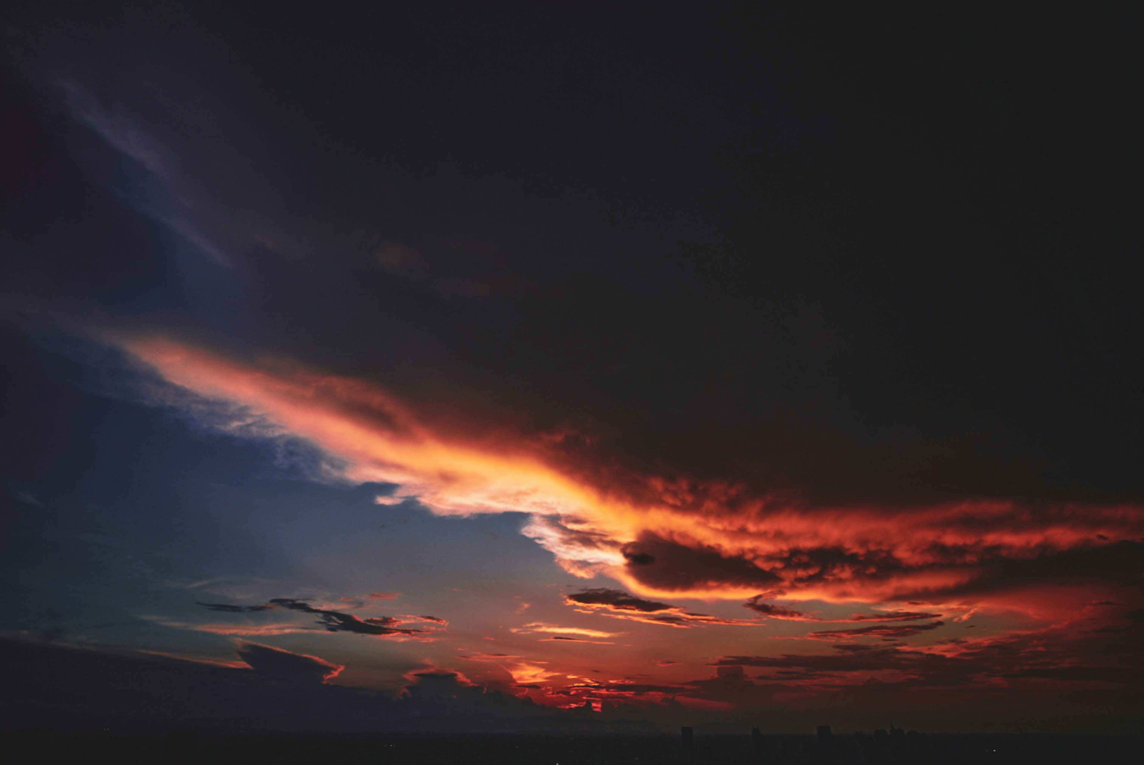 夕焼けの空に広がる色彩のグラデーションと暗い雲