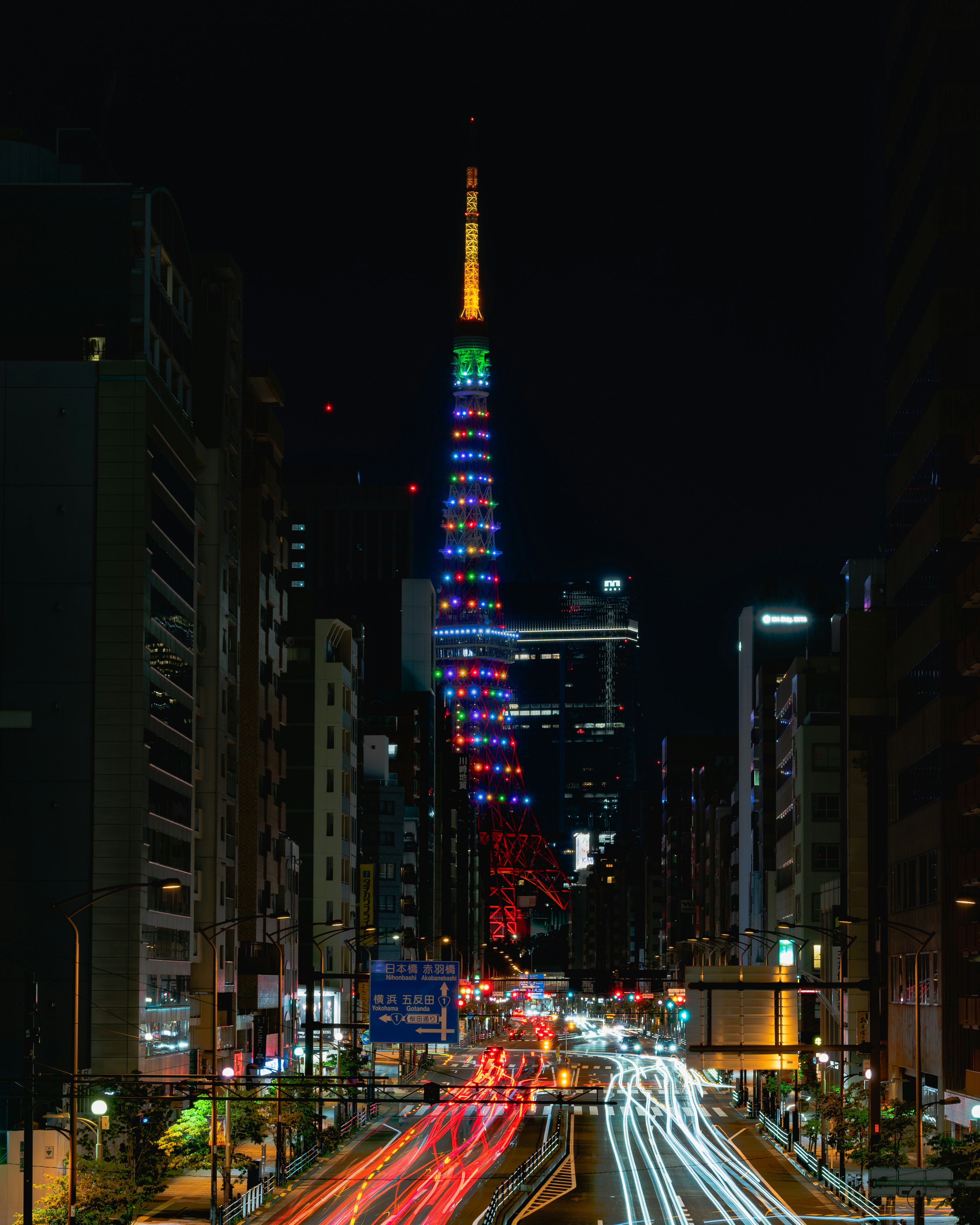 東京タワーが夜に色とりどりにライトアップされている光景