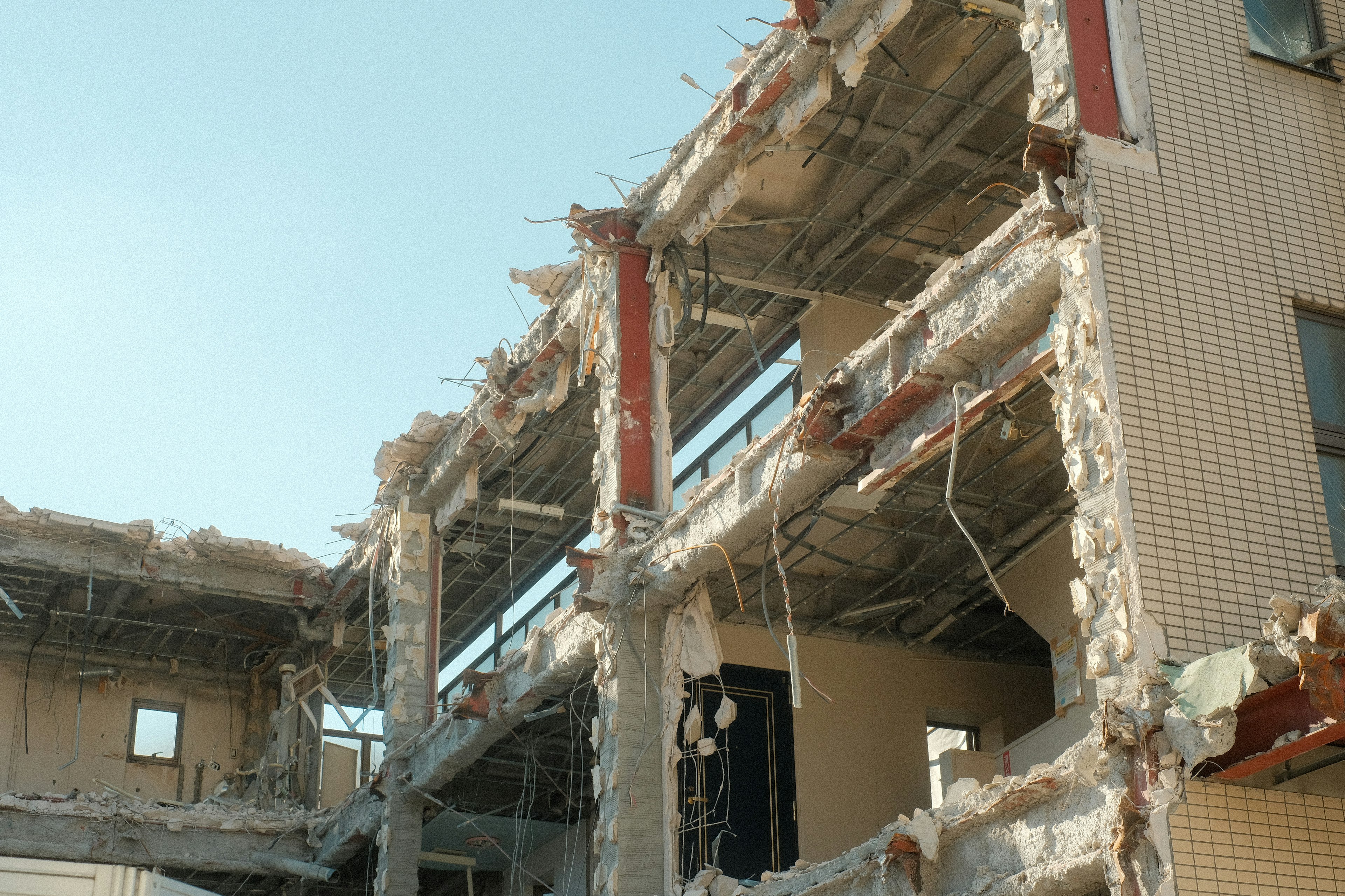 Photo of a collapsed building showing exposed walls and beams