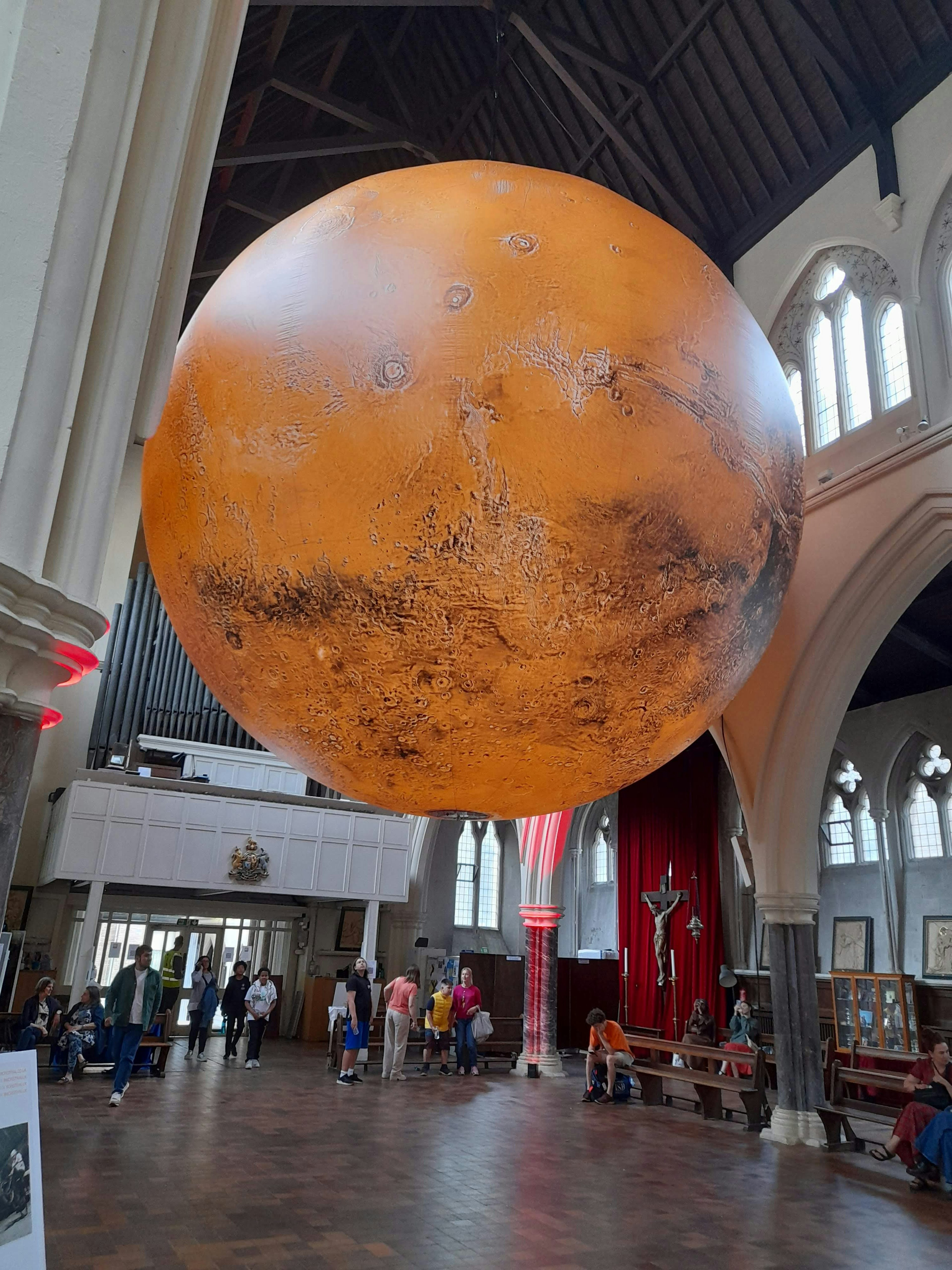 Ein großes Modell des roten Planeten, das im Inneren einer Kirche hängt