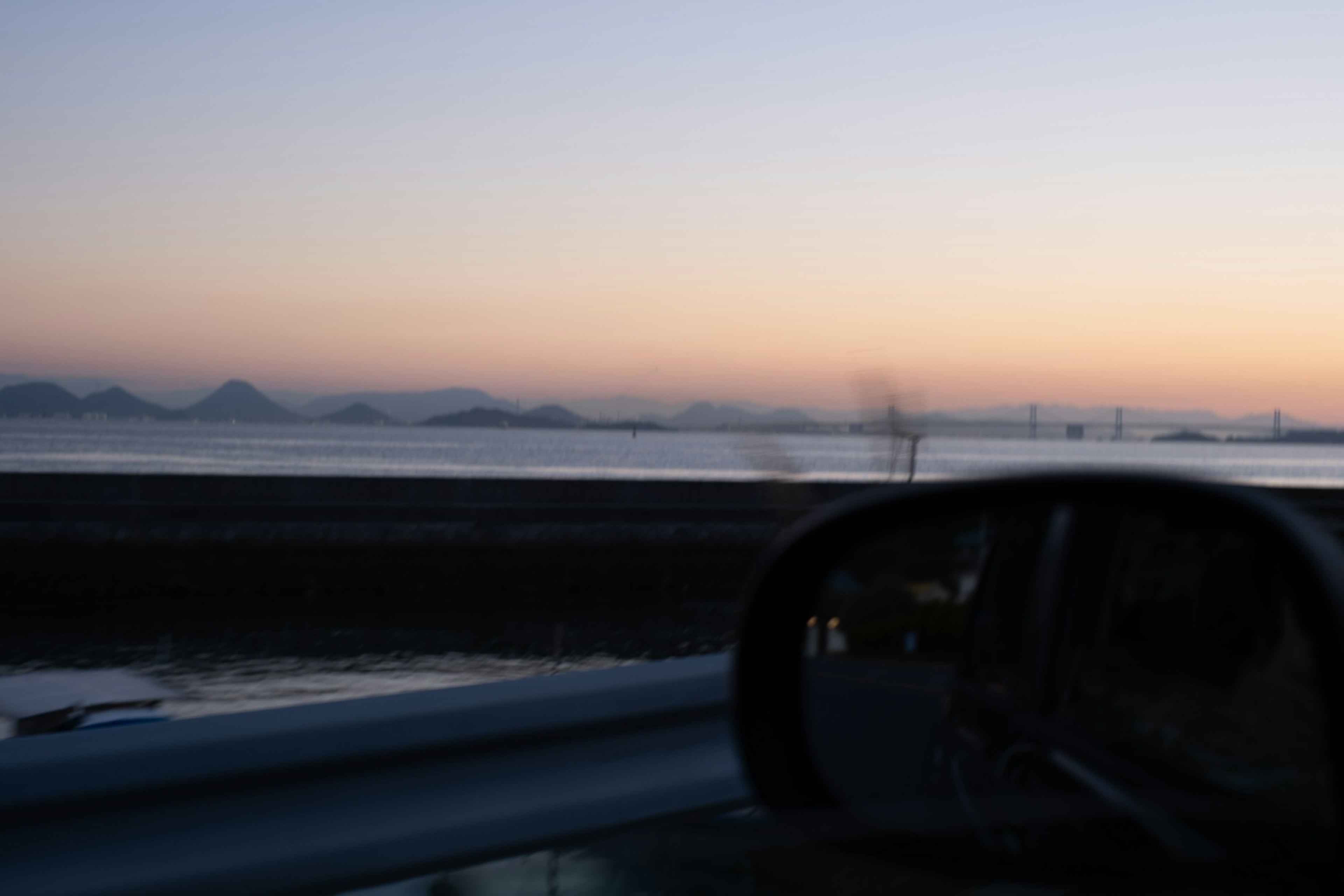 Vue du crépuscule sur la mer et le rétroviseur de la voiture