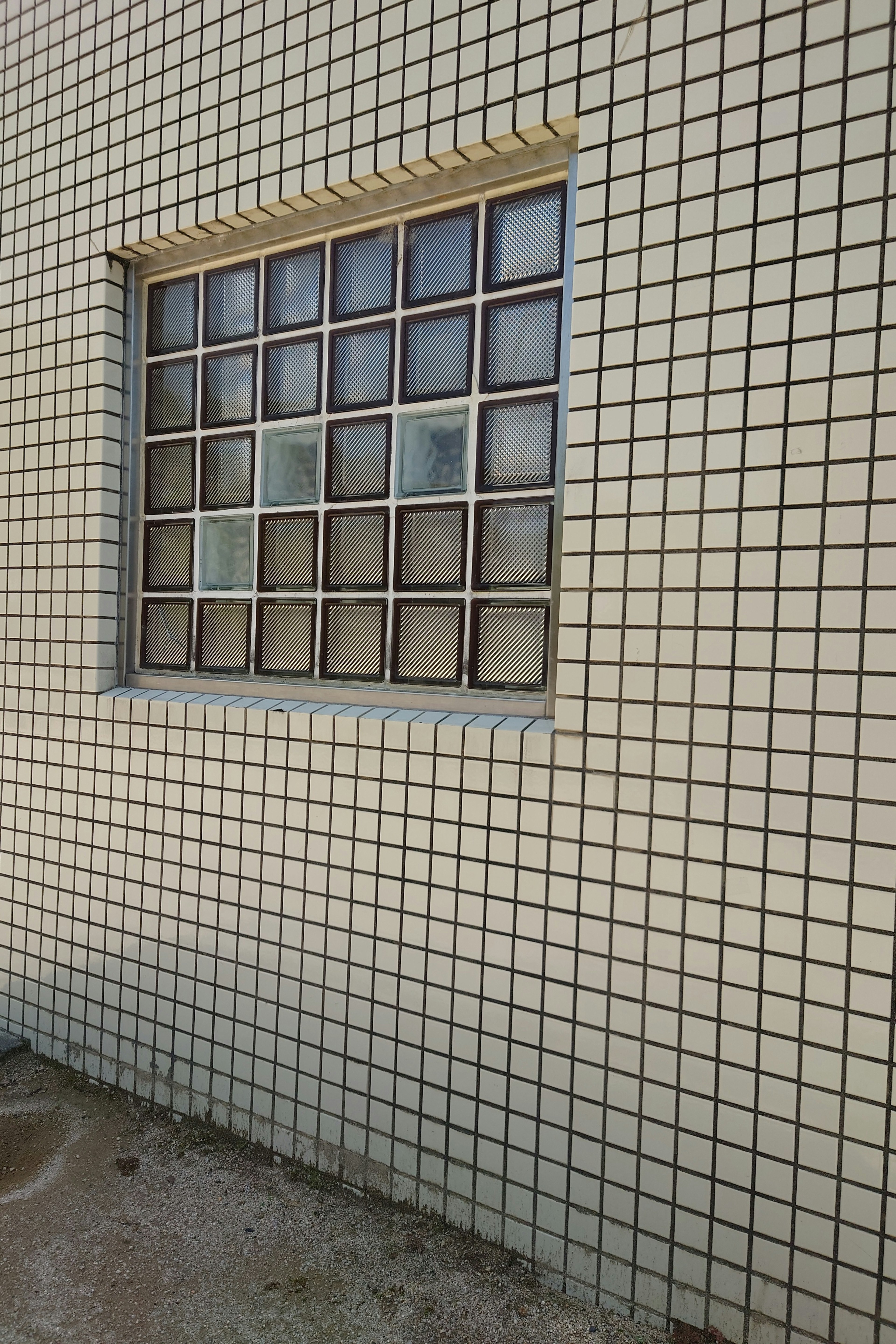 Fenêtre en blocs de verre installée dans un mur carrelé blanc