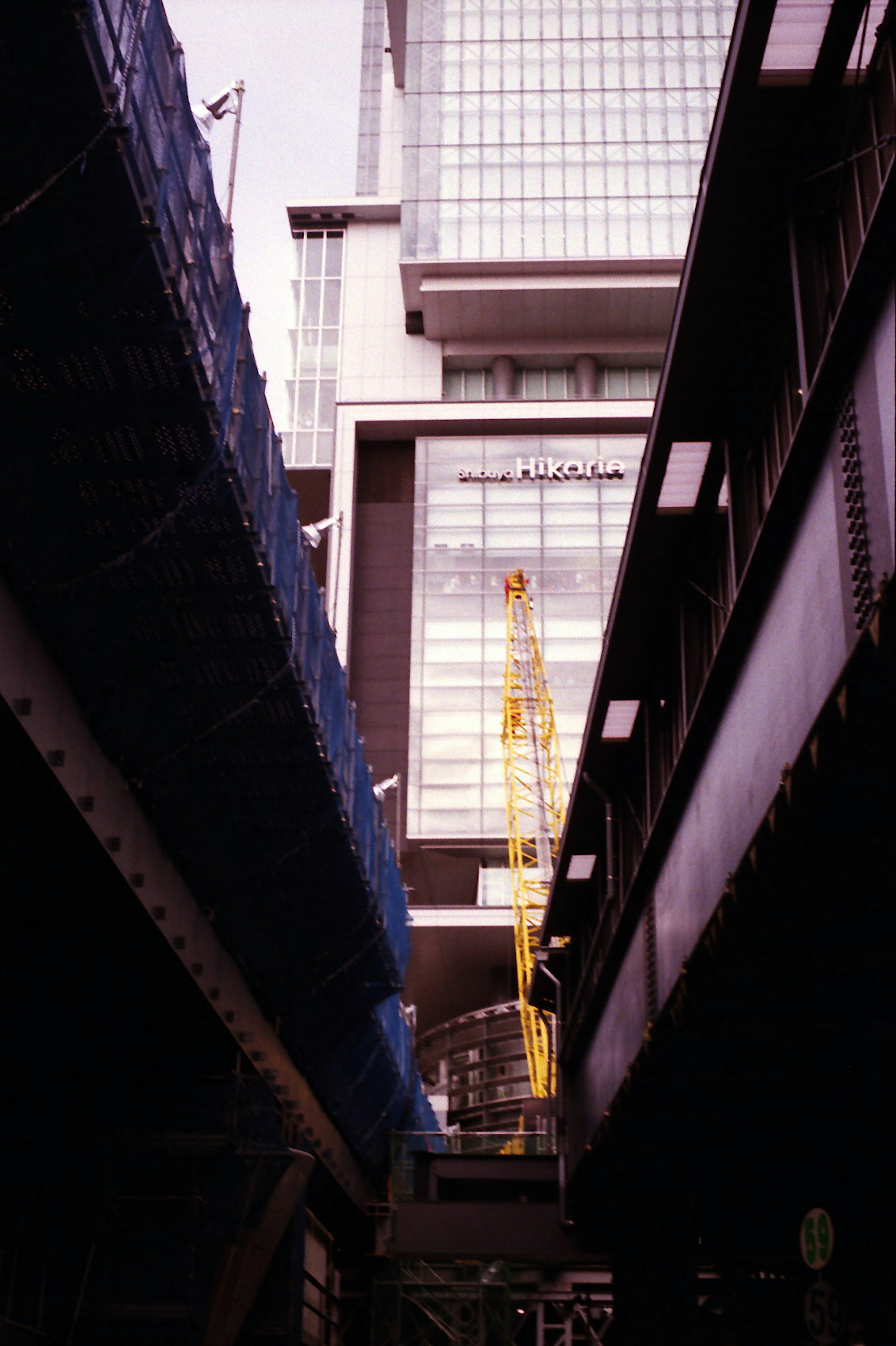 Construction crane between high-rise buildings with glass facade