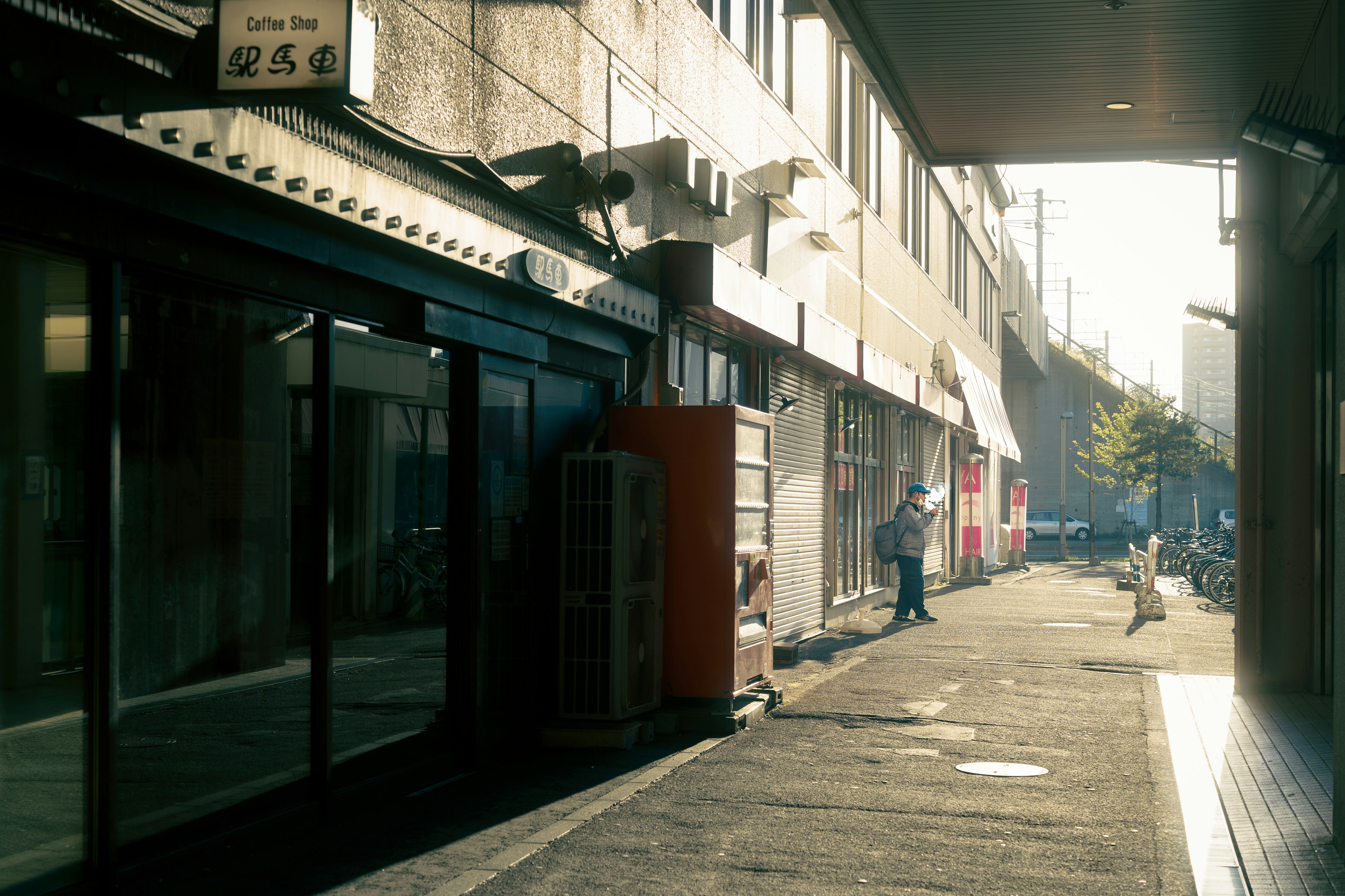 静かな街道に沿った店舗と人々の姿を捉えた画像