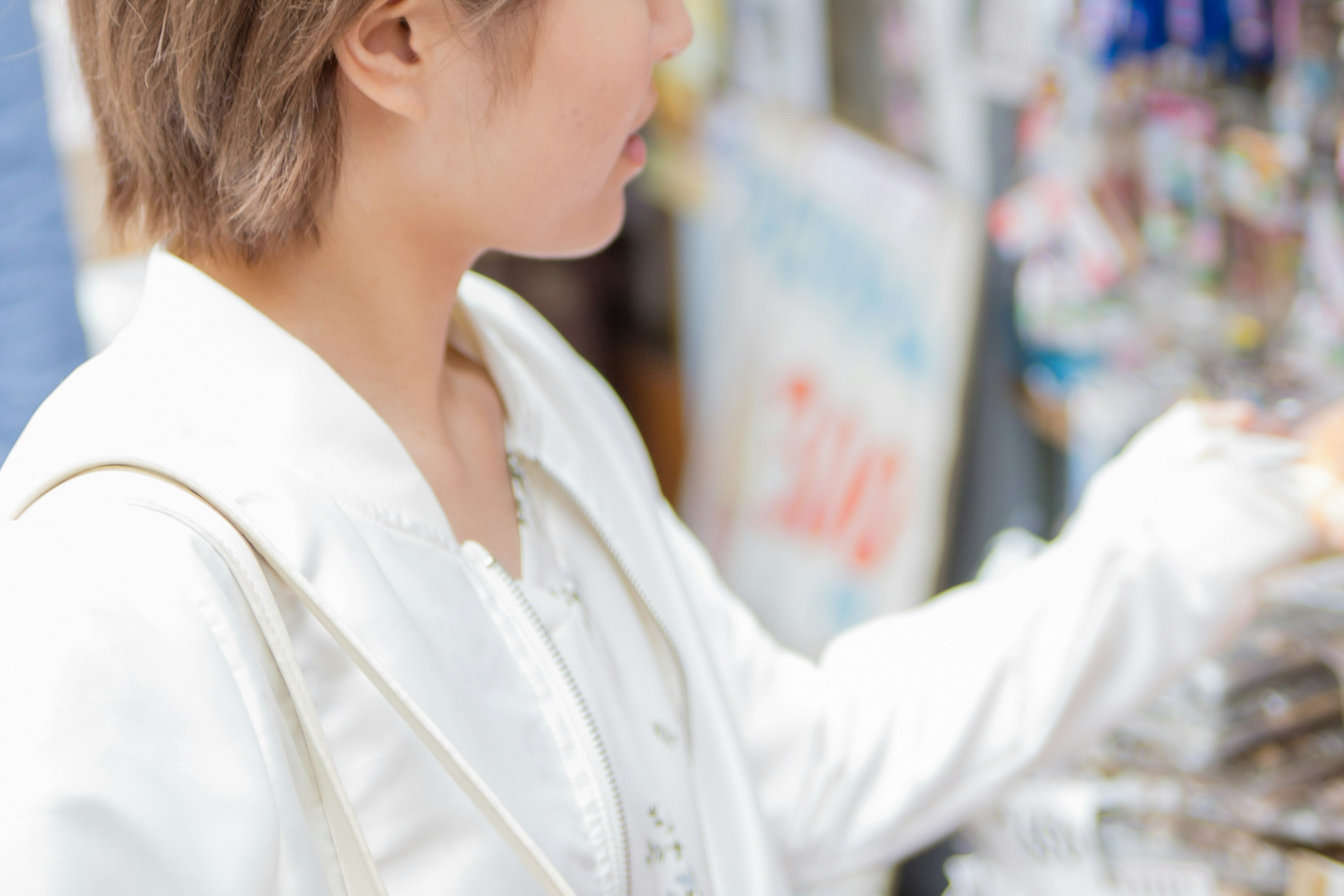 Une femme prenant des articles vêtue d'une veste blanche