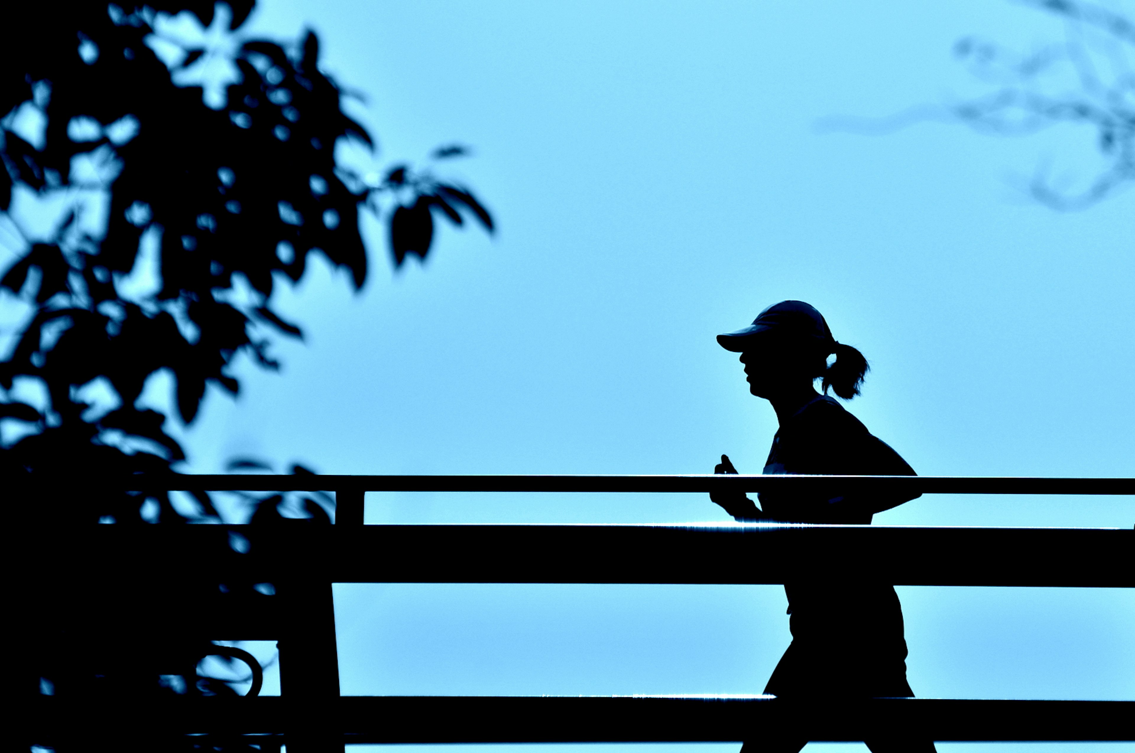 Silhouette d'une femme courant sur fond bleu