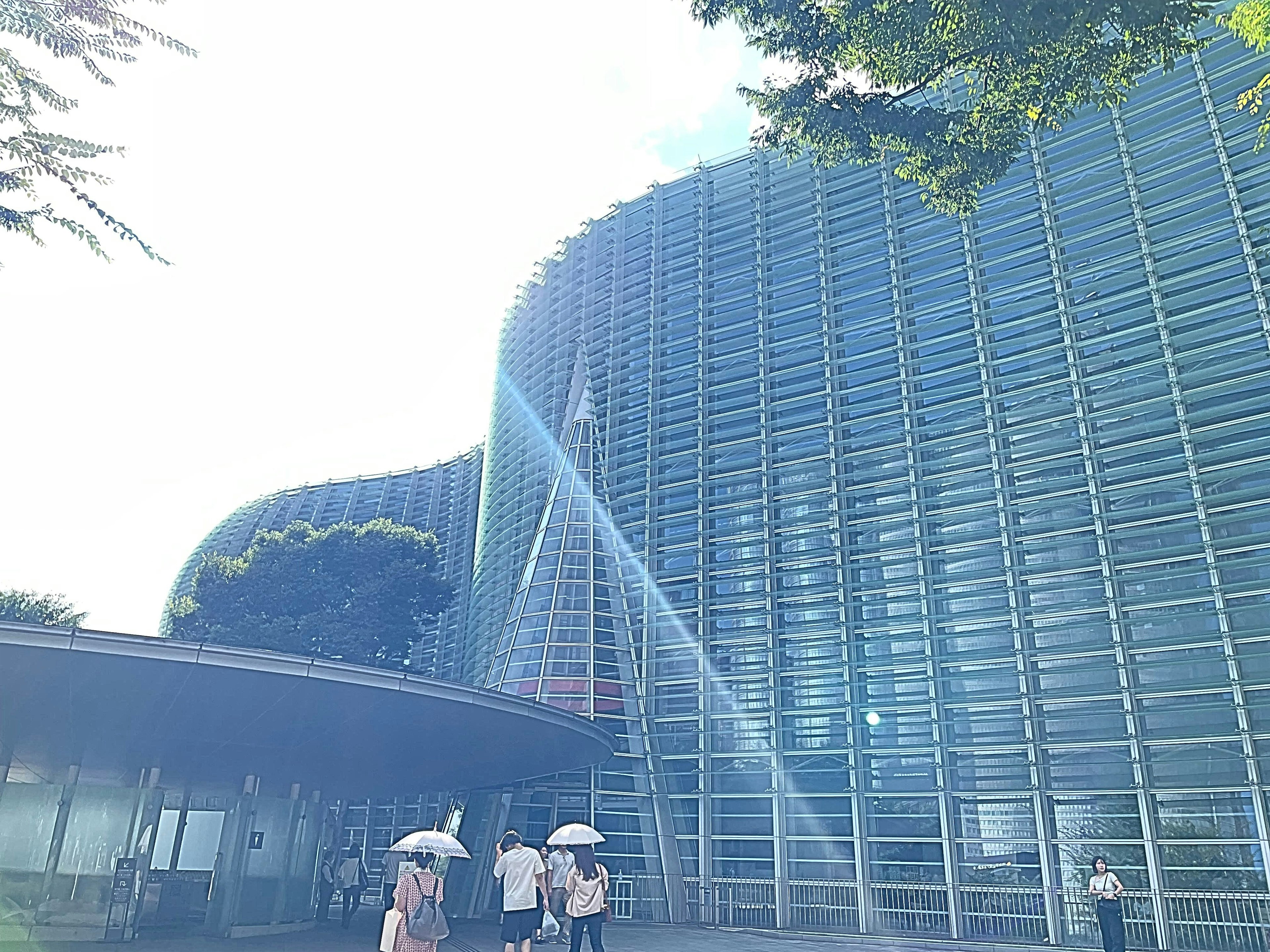 Bâtiment moderne en verre avec des visiteurs marchant devant