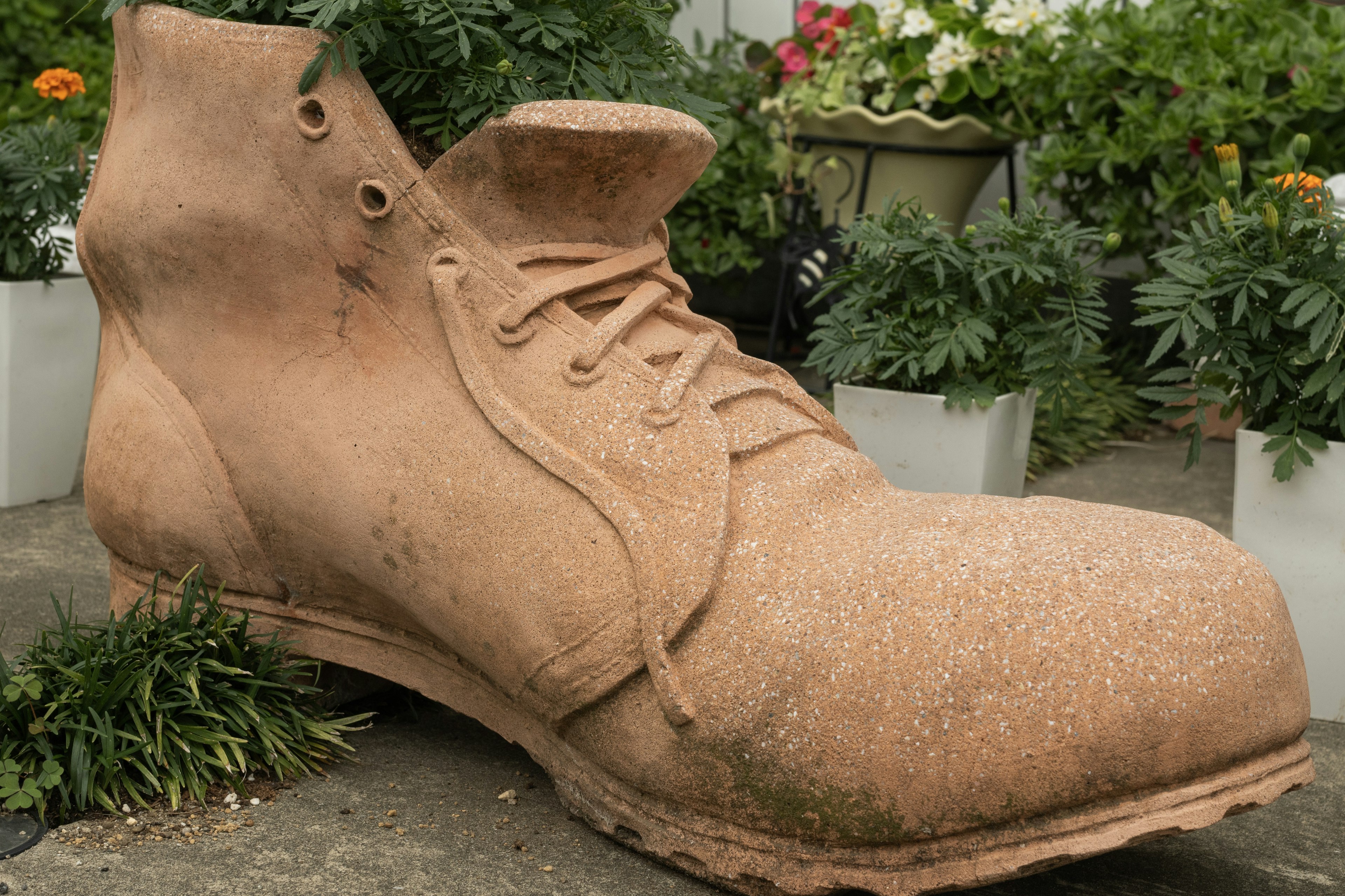 Grande scultura di scarpa posizionata in un giardino