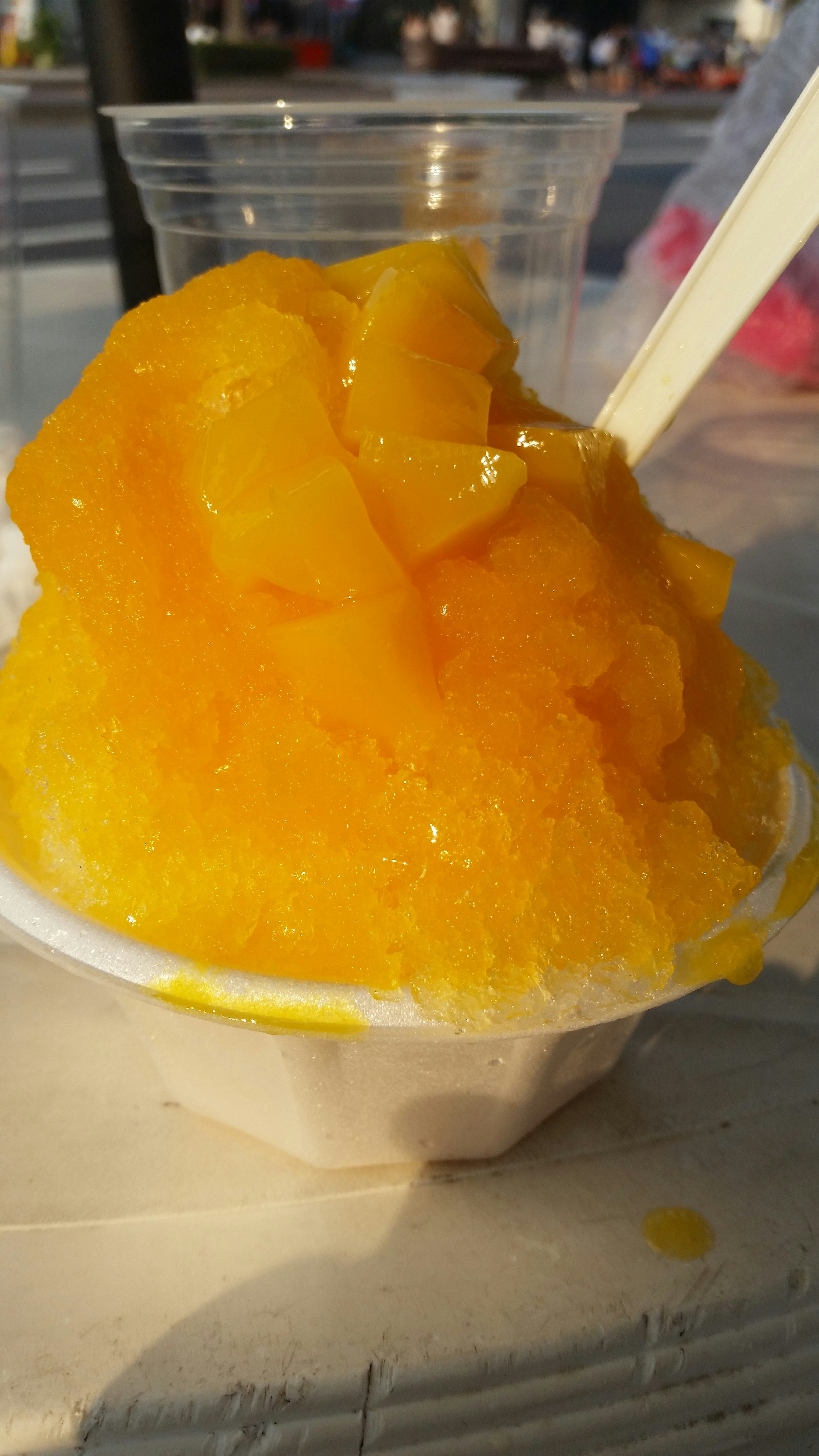 Vibrant yellow shaved ice dessert in a cup