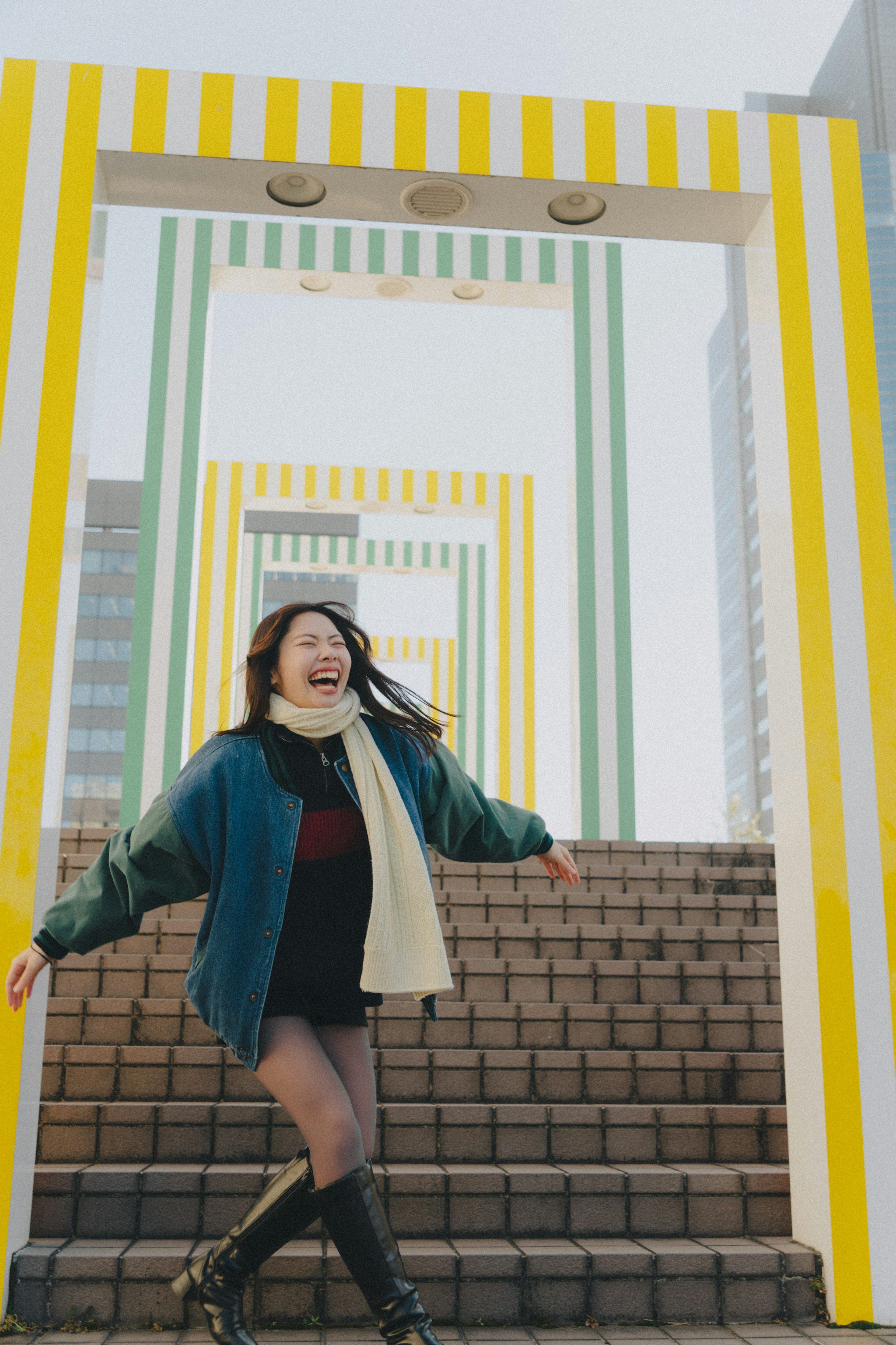 Una mujer sonriente corriendo alegremente por las escaleras en un entorno brillante