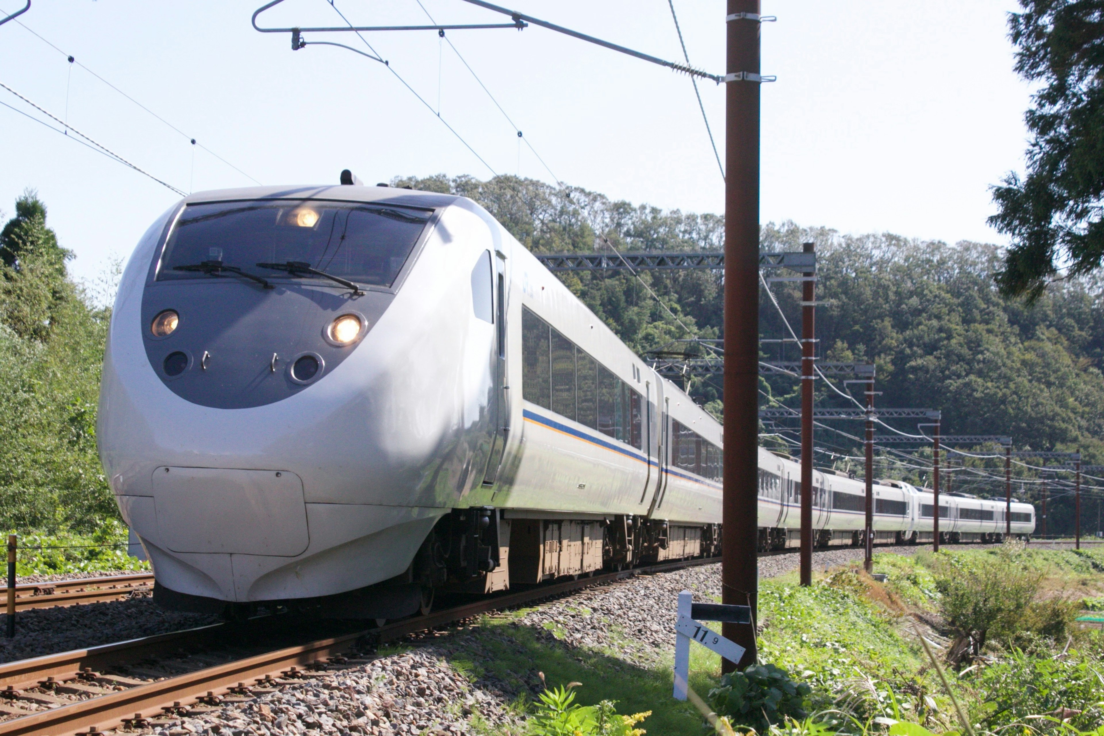 Train Shinkansen blanc traversant un paysage verdoyant