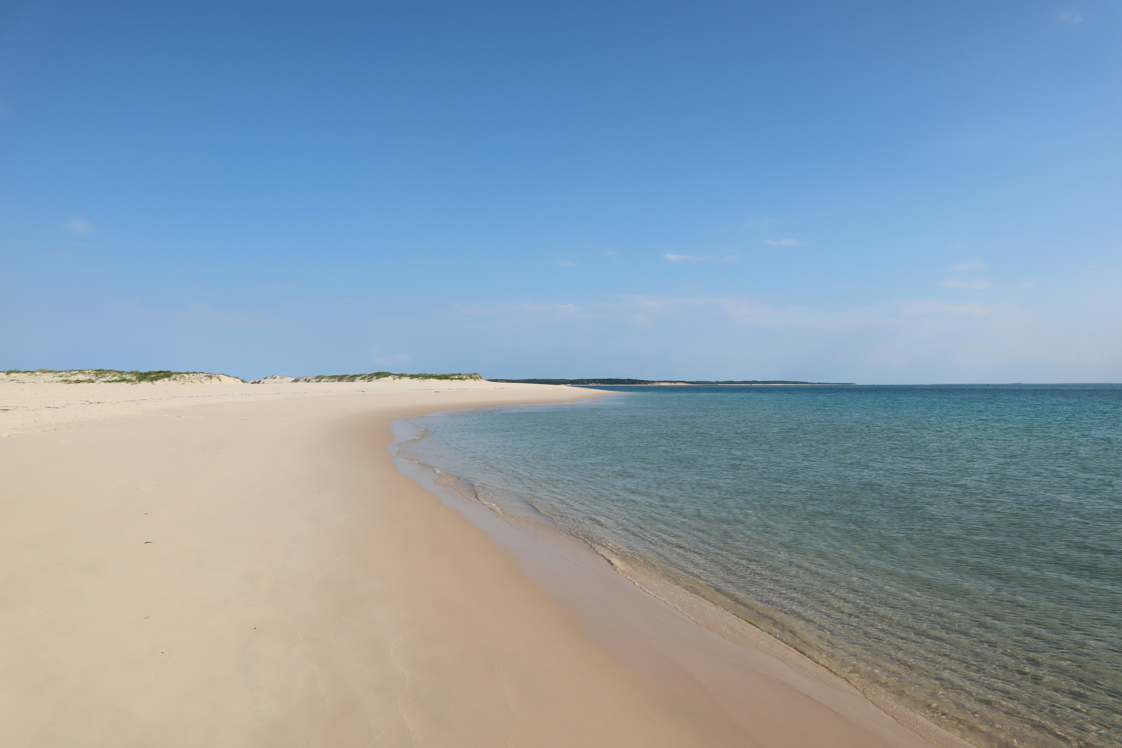 Pemandangan pantai yang indah dengan langit biru cerah dan laut tenang