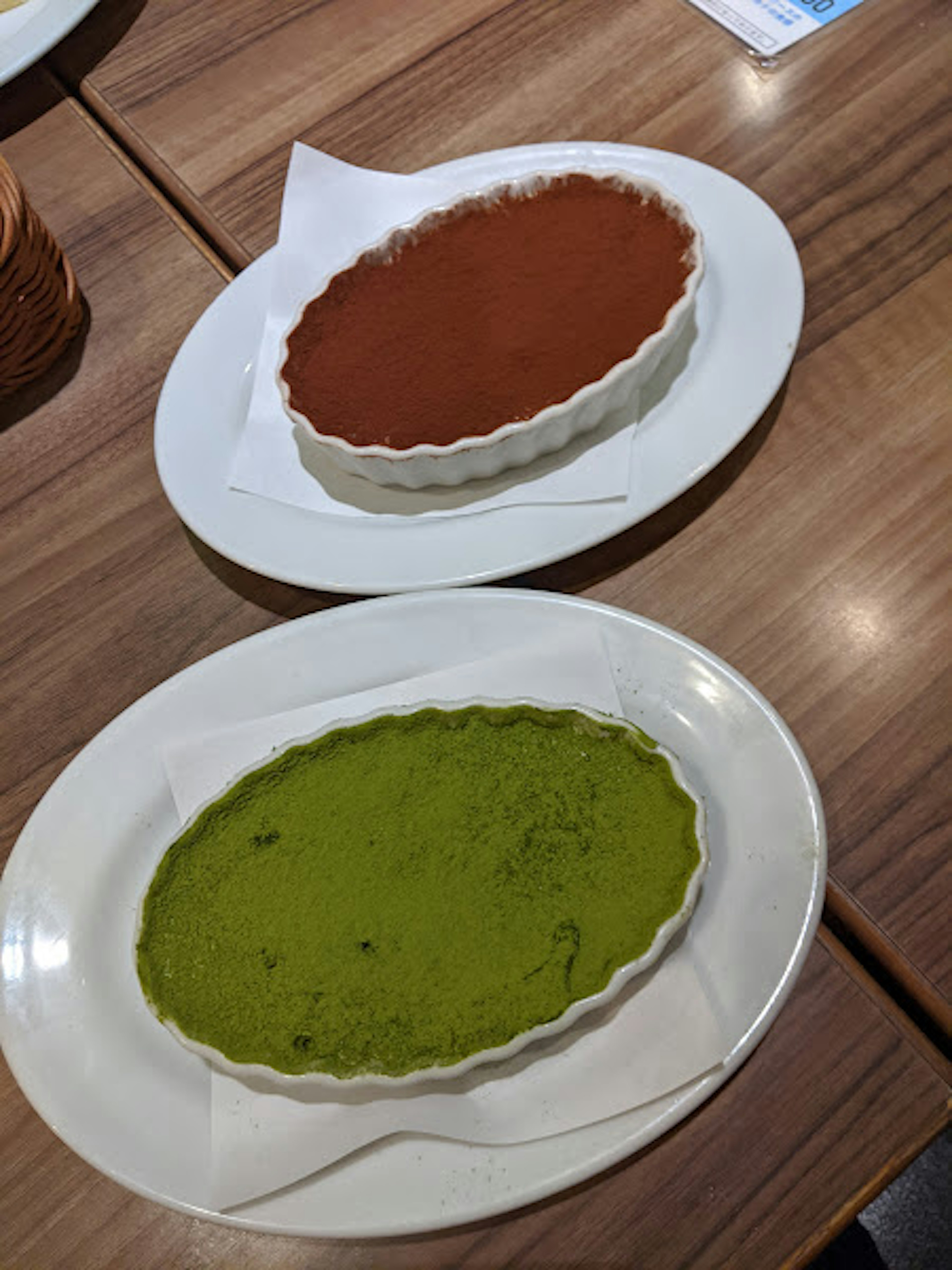 Two plates featuring matcha and chocolate tarts