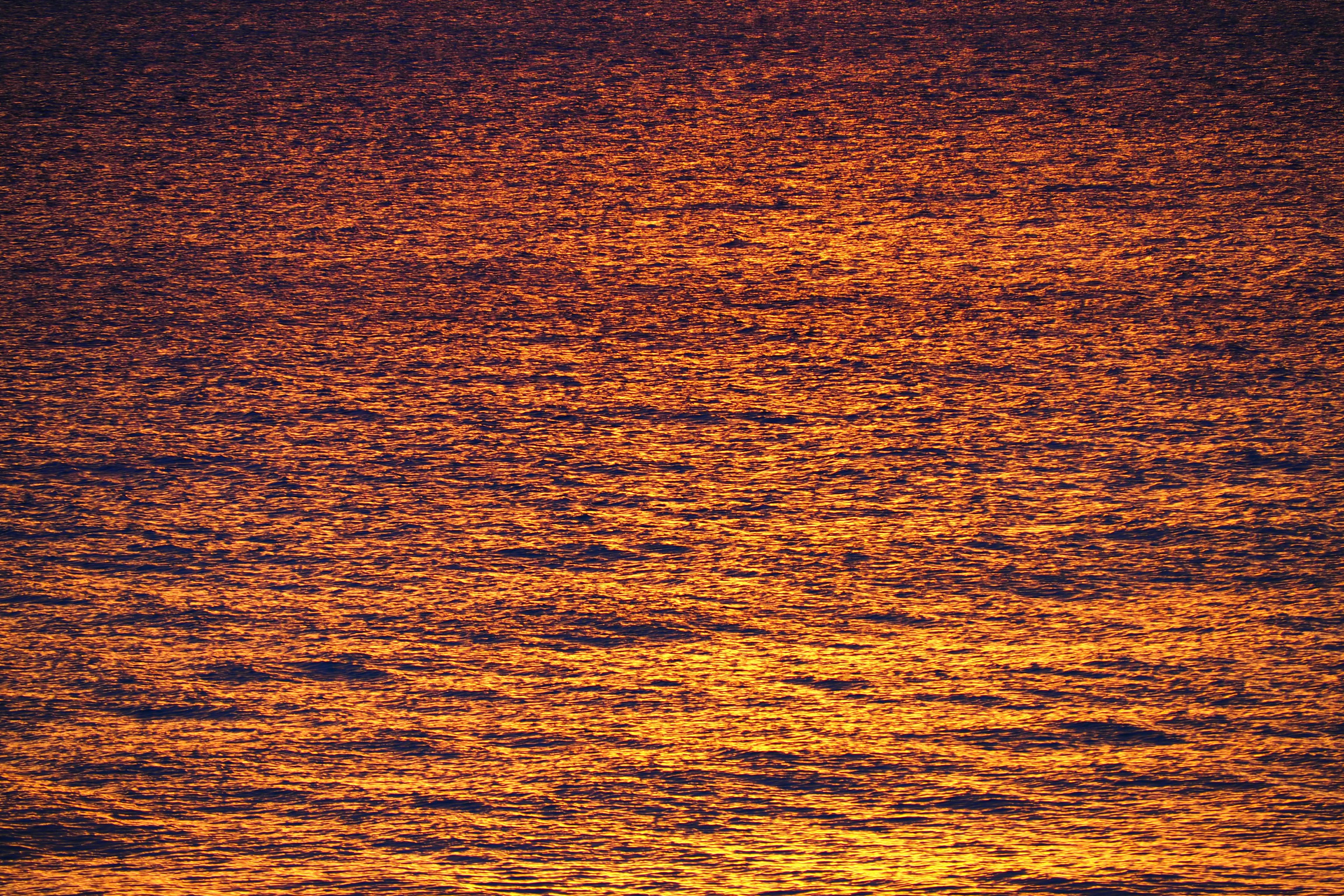 Surface of the sea reflecting orange hues