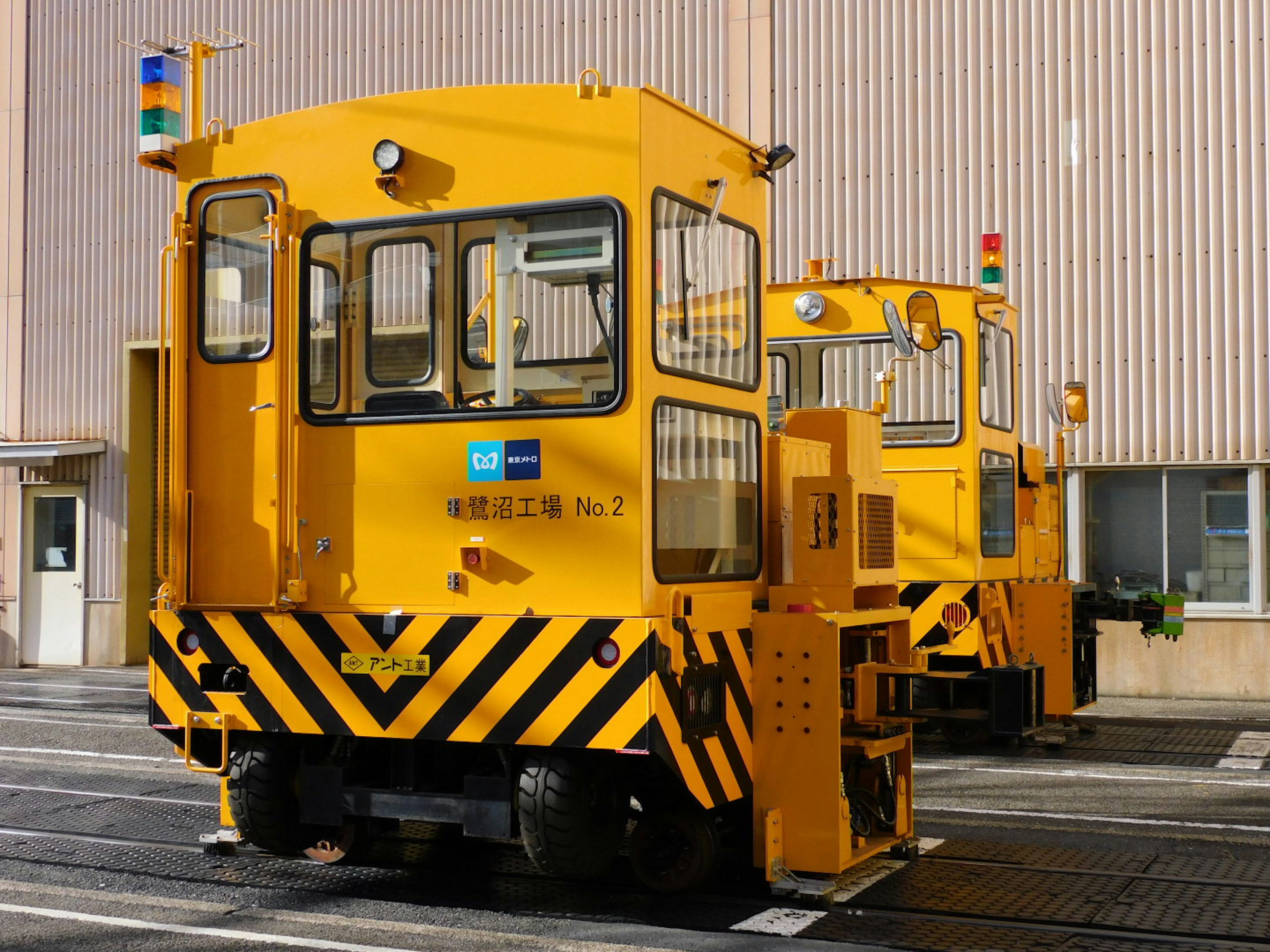 Two yellow industrial vehicles parked outside a building