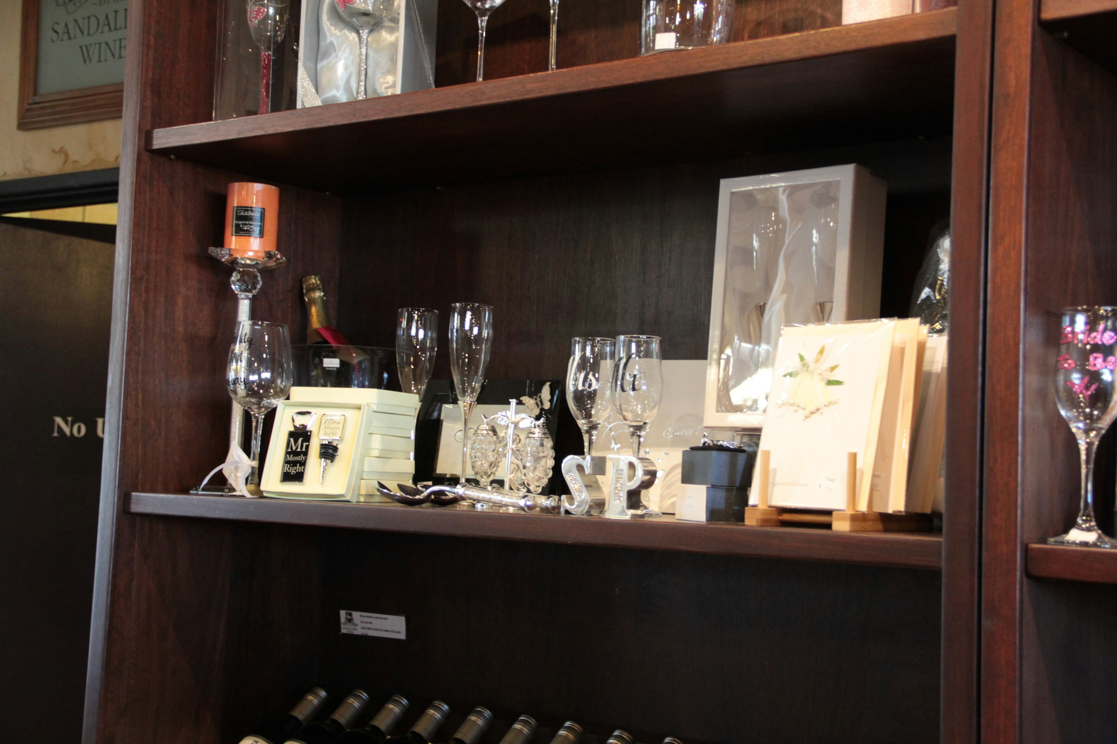 Collection of glasses and decorative items on a wooden shelf