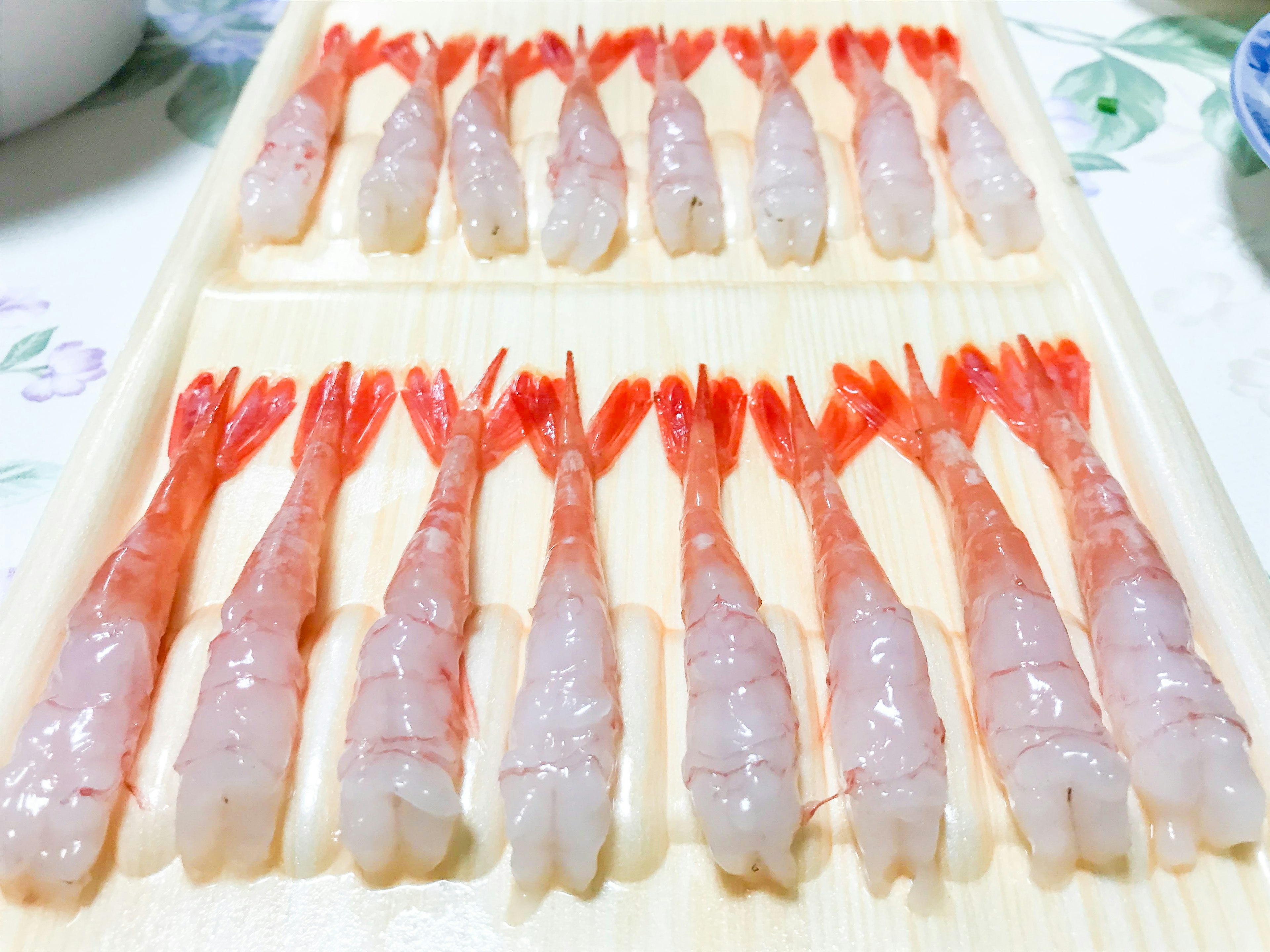 Fresh shrimp arranged neatly on a wooden tray