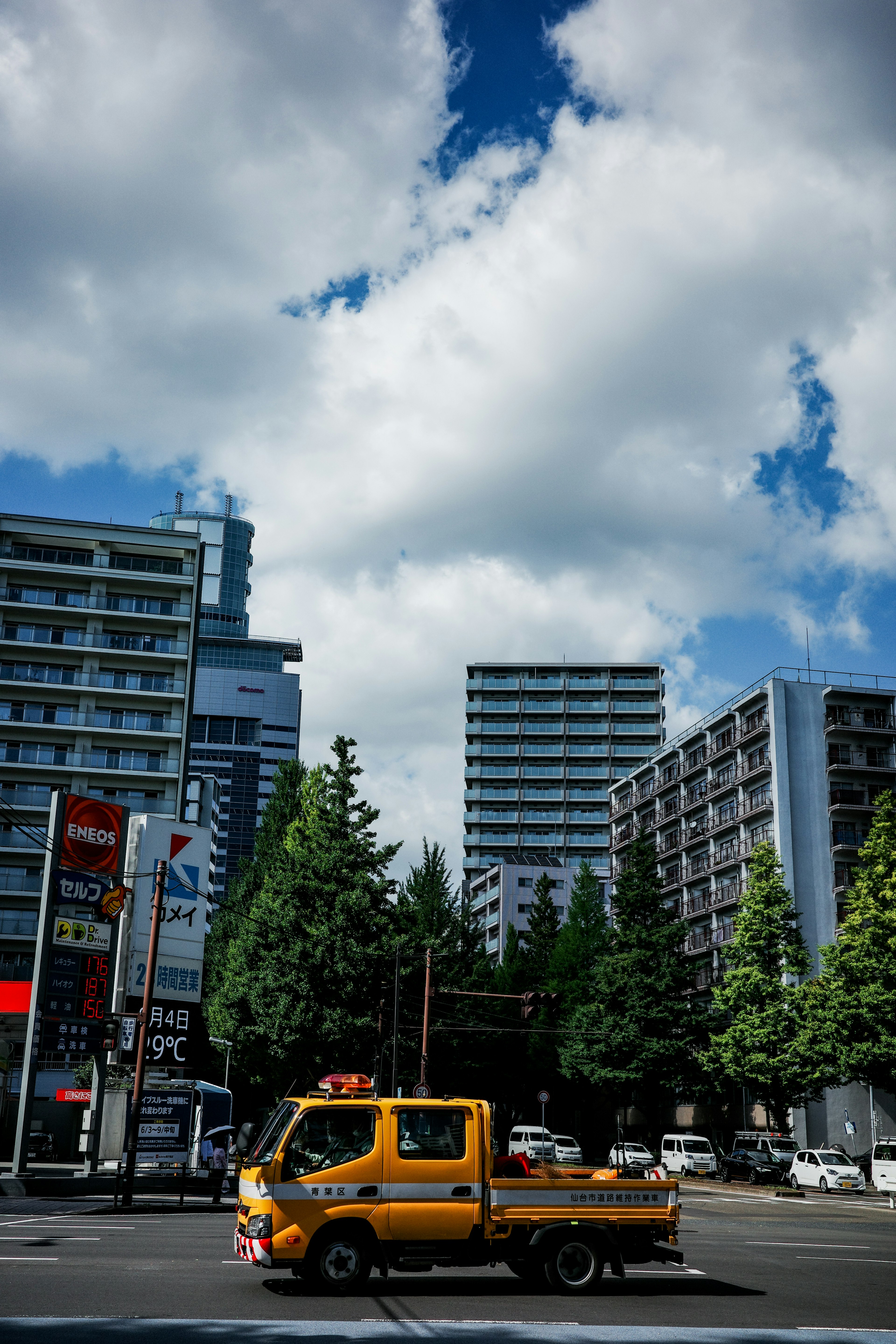 城市街道上的黄色卡车与高楼大厦和蓝天