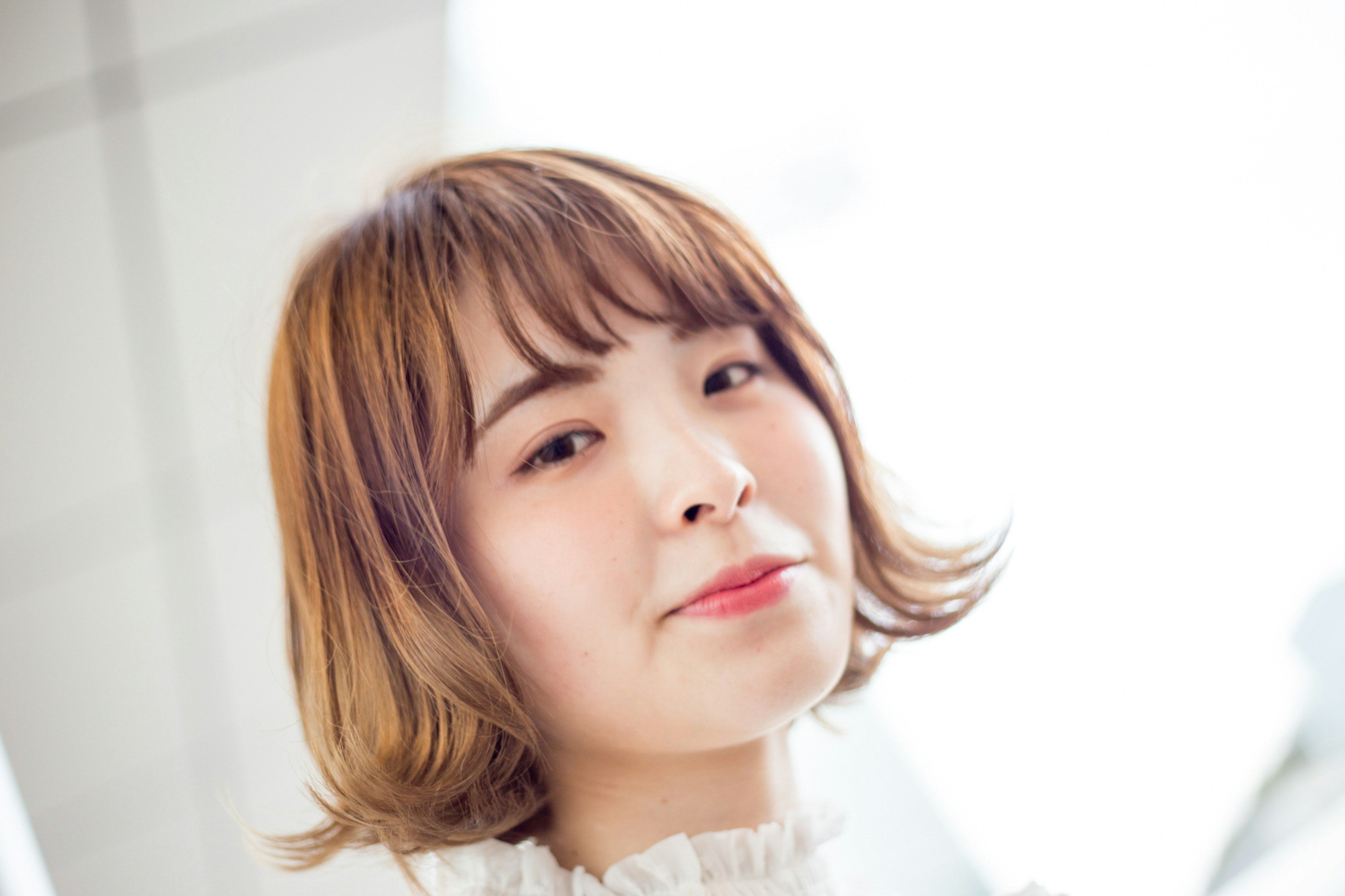 Portrait of a young woman smiling with a bright background