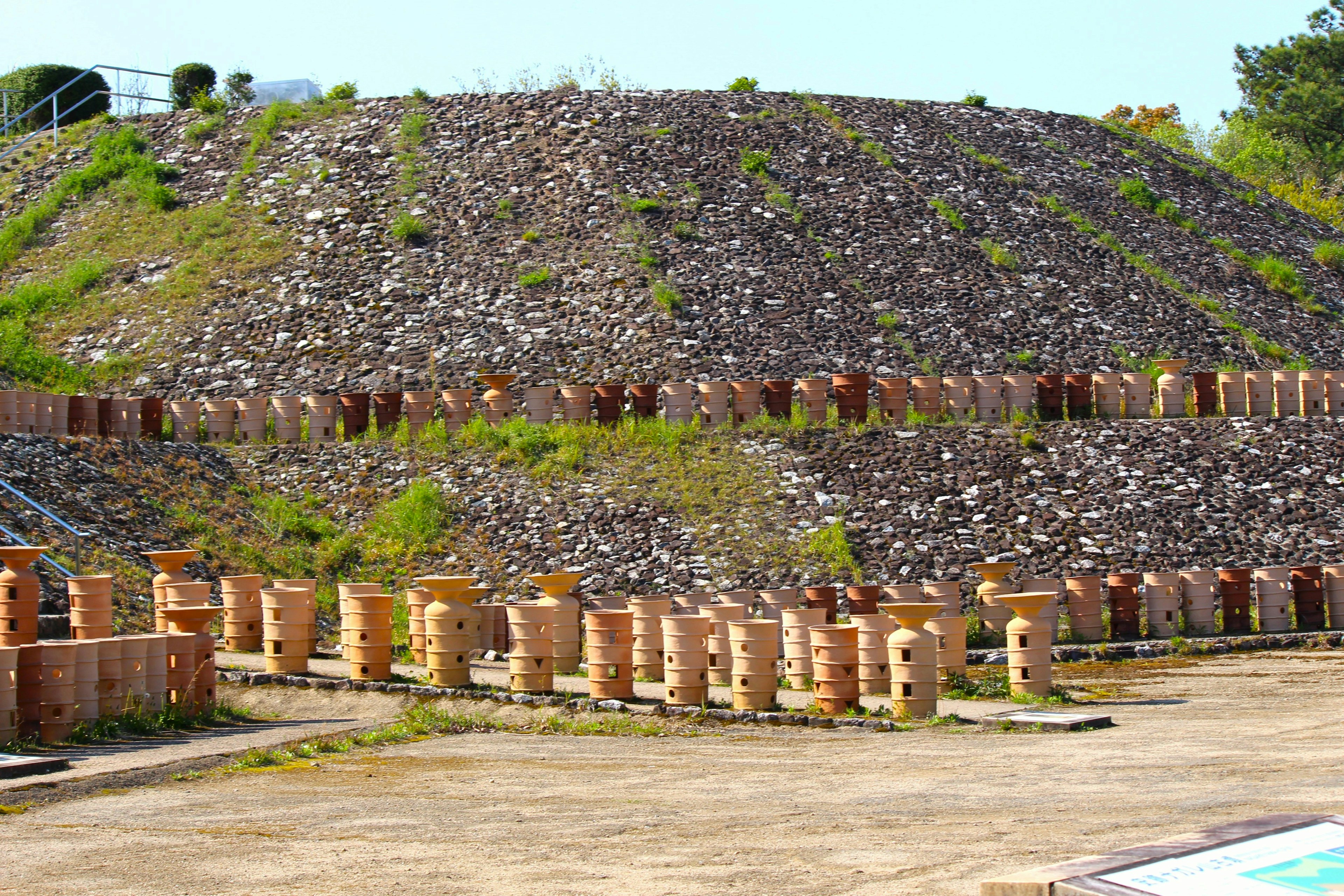 Green hillside with concrete foundations and aligned brick columns