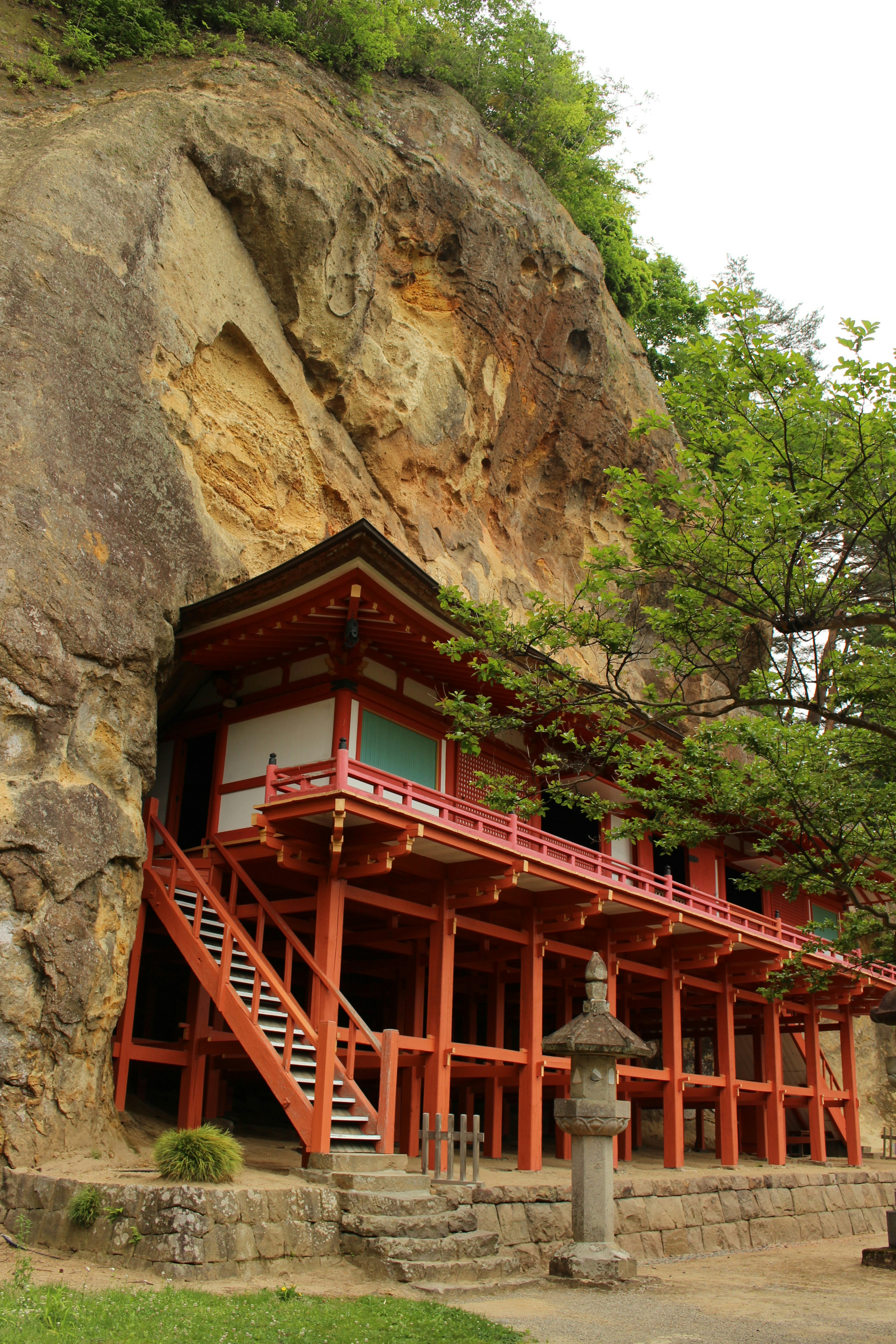 紅色建築依偎在岩石懸崖旁