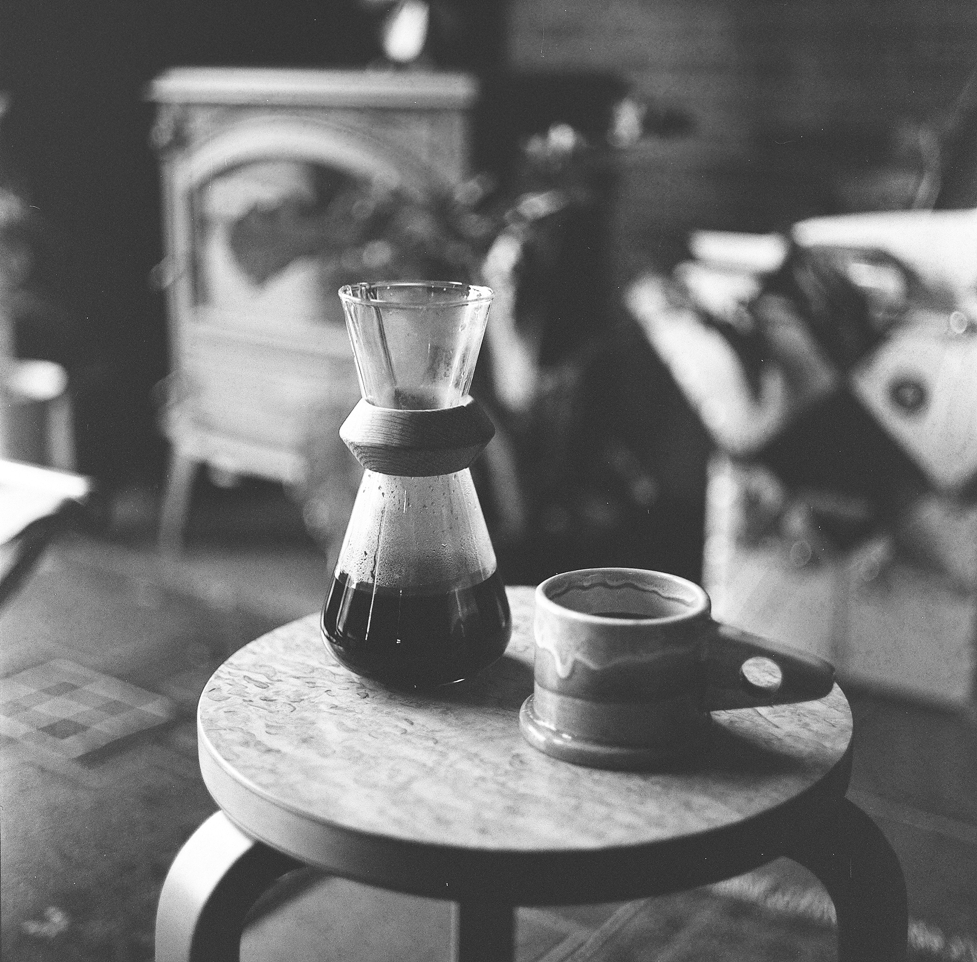 Pote de café y taza sobre una mesa de madera