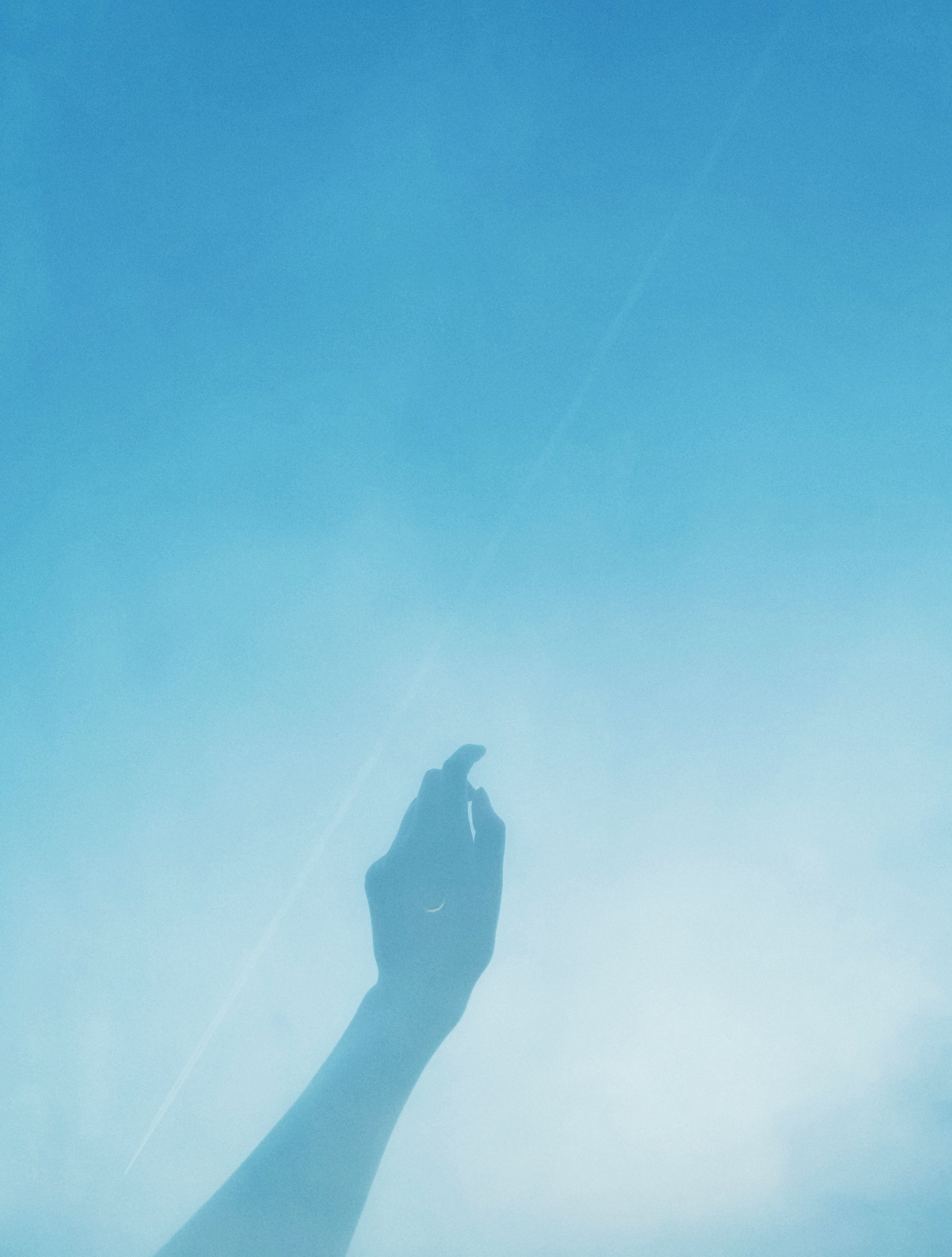 Photo of a hand silhouette against a blue background