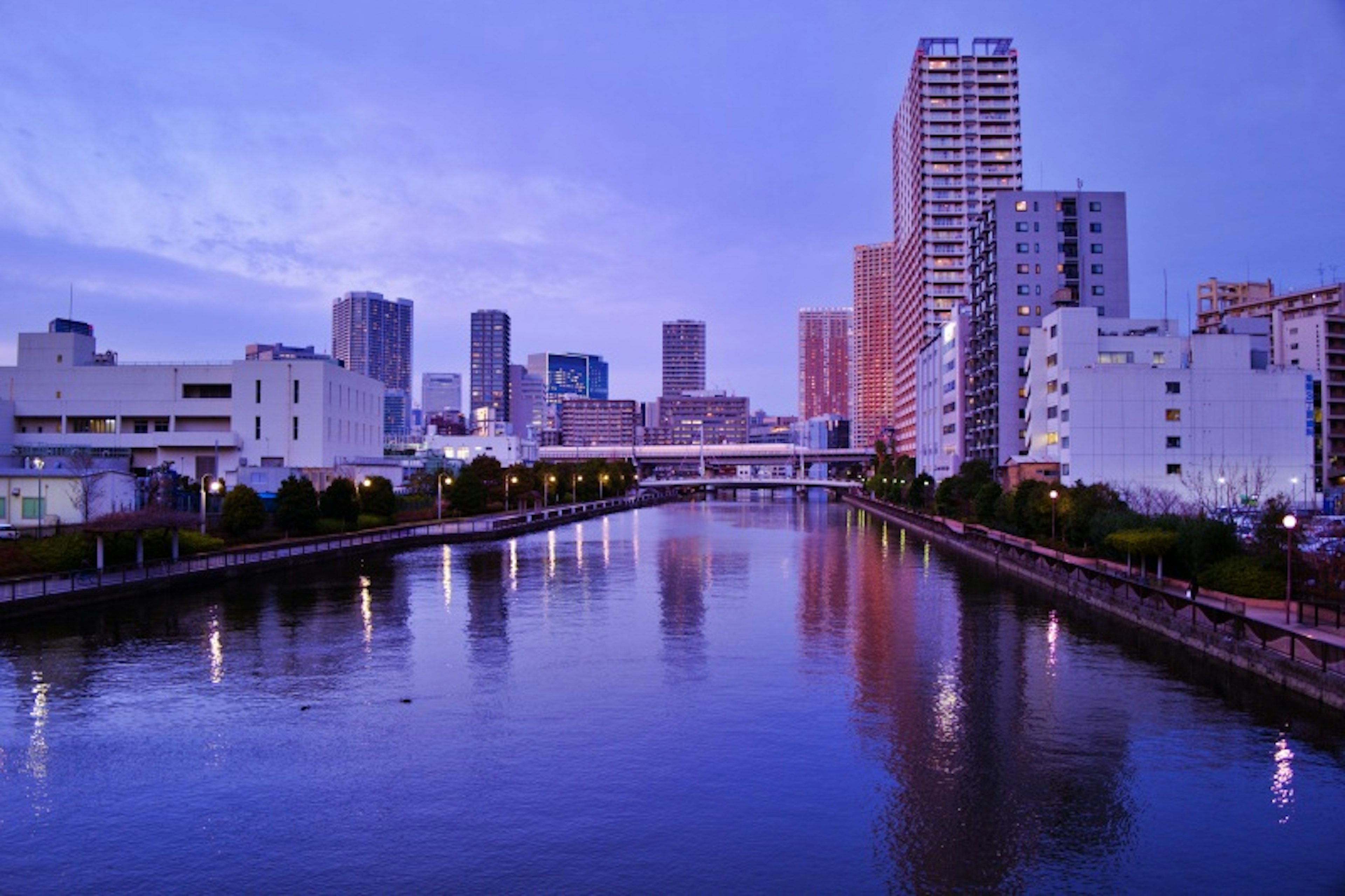 川沿いの都市風景と青紫の空のシルエット