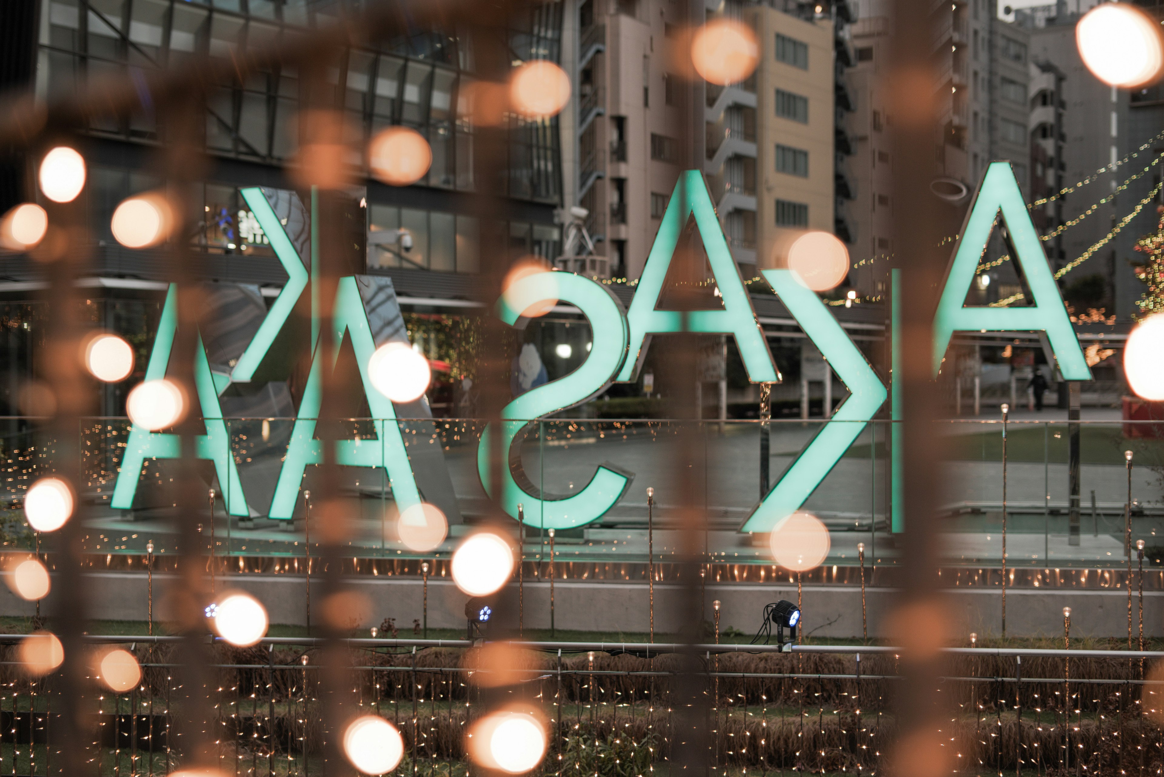 Reflection of blue neon letters in an urban landscape with blurred lights