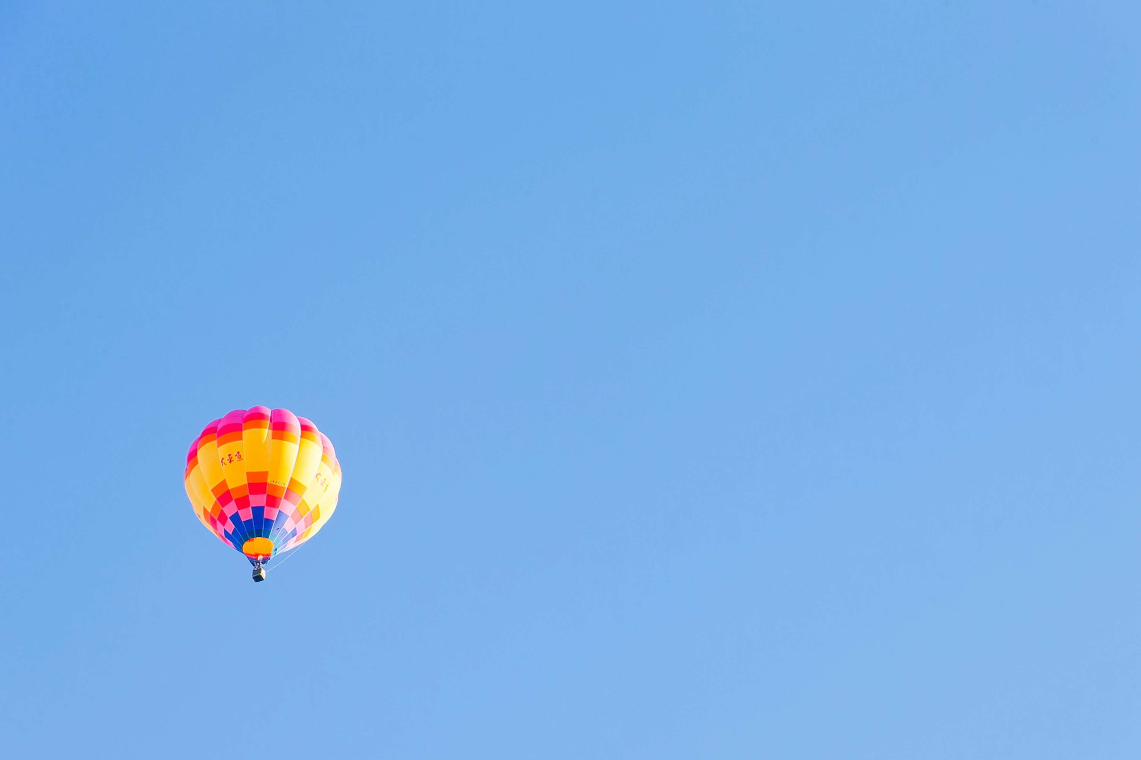 Bunter Heißluftballon schwebt in einem klaren blauen Himmel