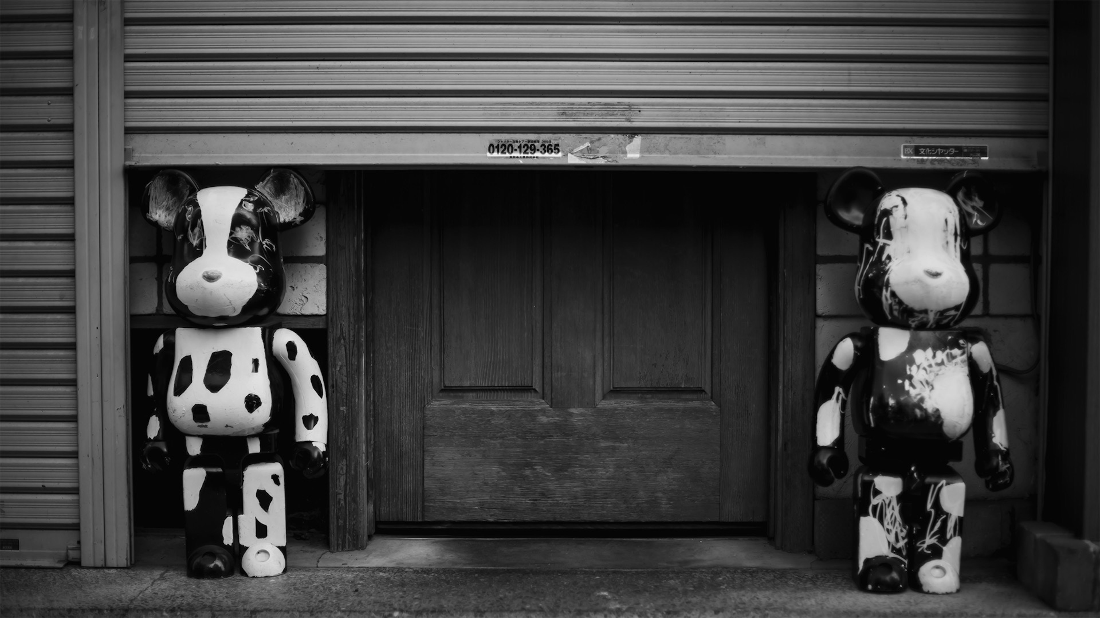 Two black and white cow sculptures standing in front of a door