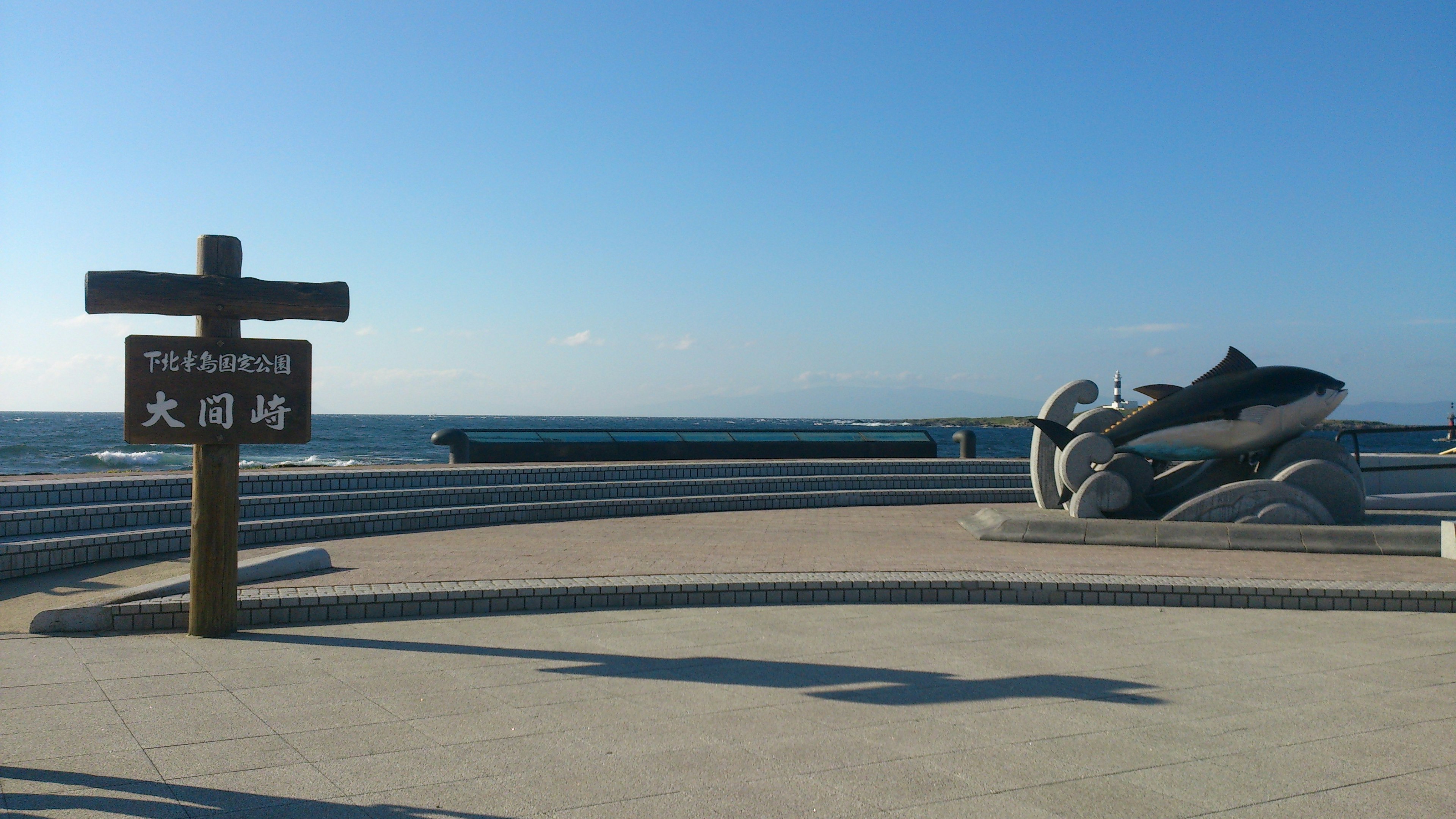 Vista escénica de un parque con una escultura de pez y fondo oceánico