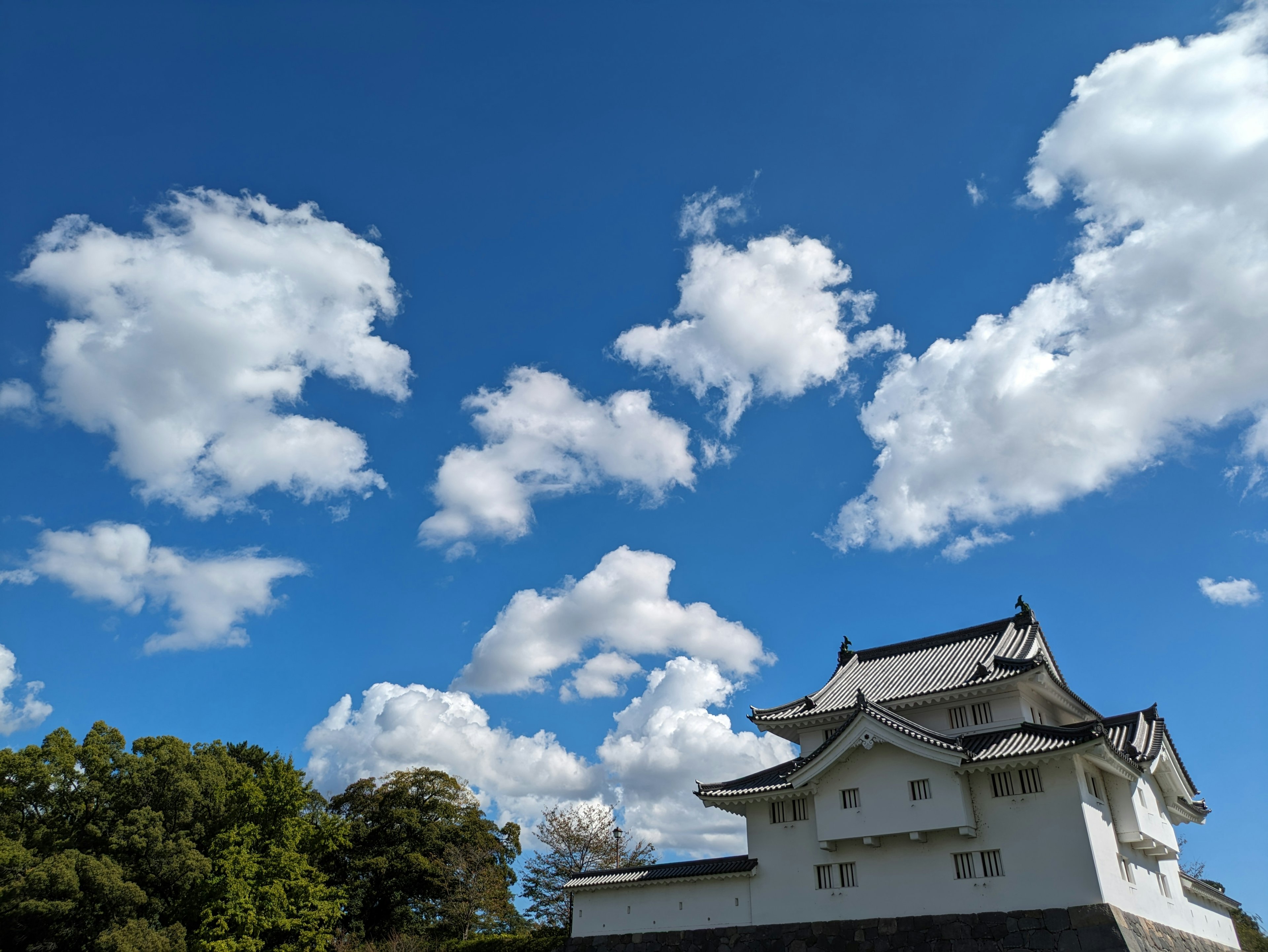 青空の下に立つ日本の城と白い雲