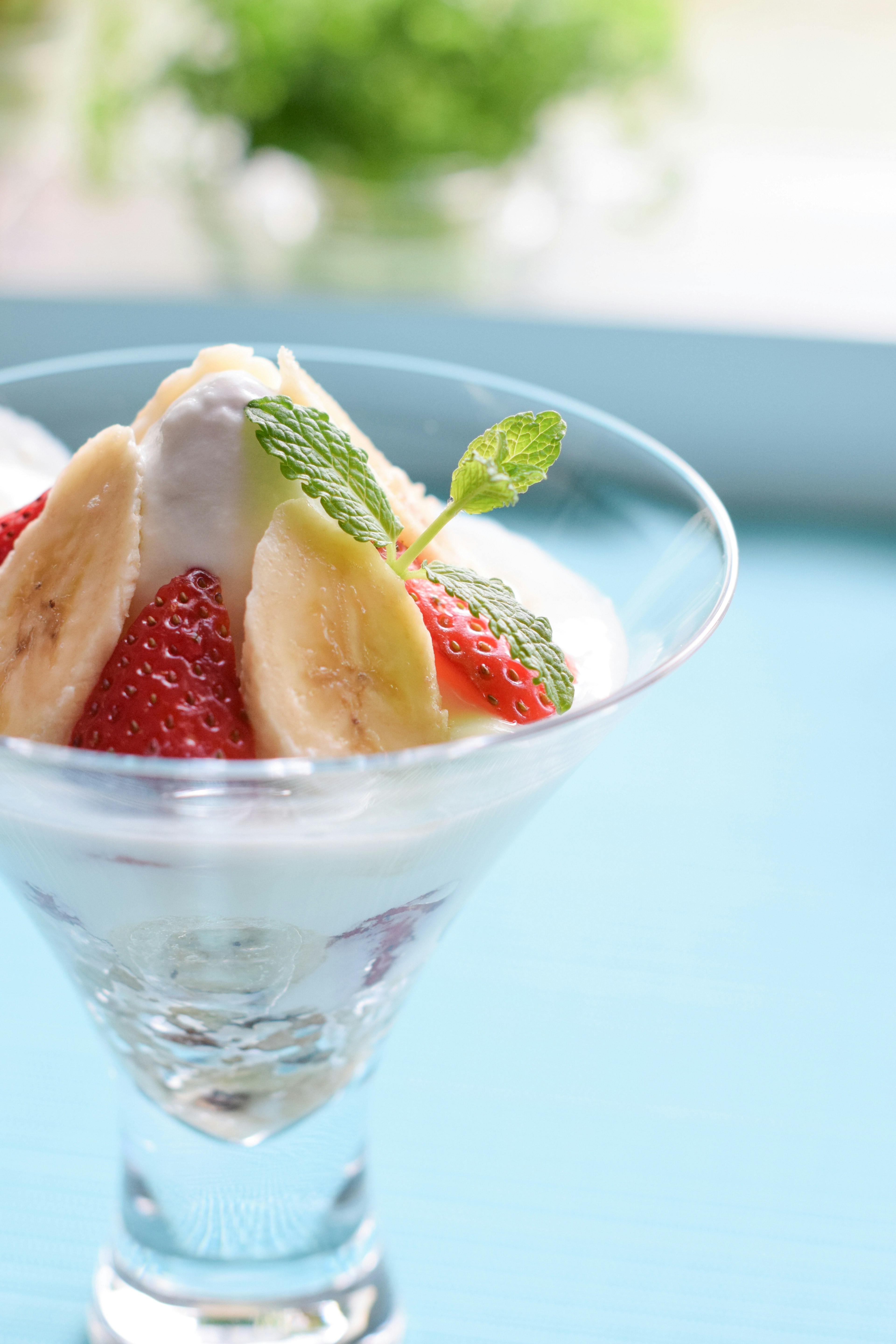 Coupe de dessert avec de la crème garnie de fraises et de bananes