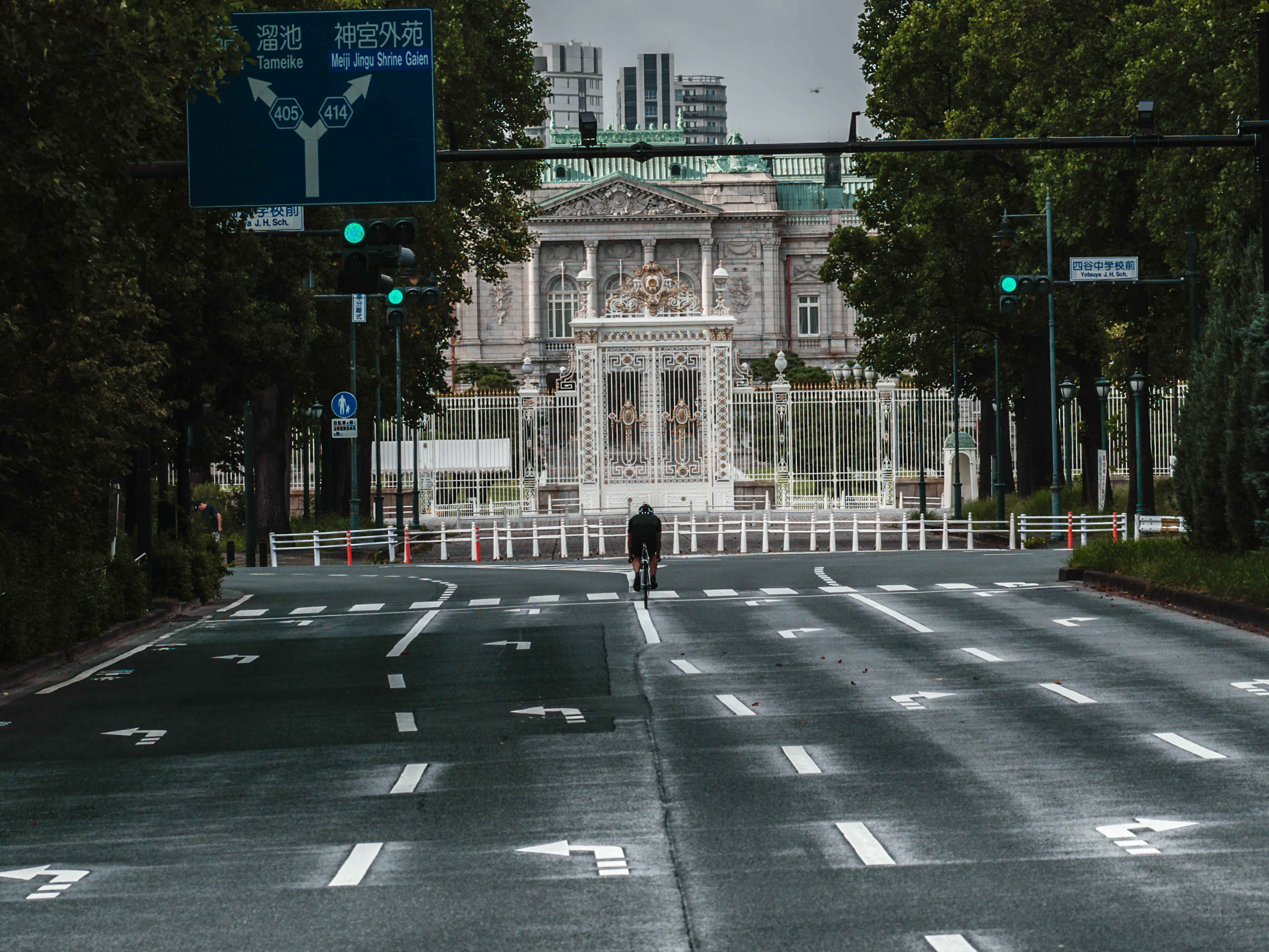 A person standing on a quiet street with a historic building in the background