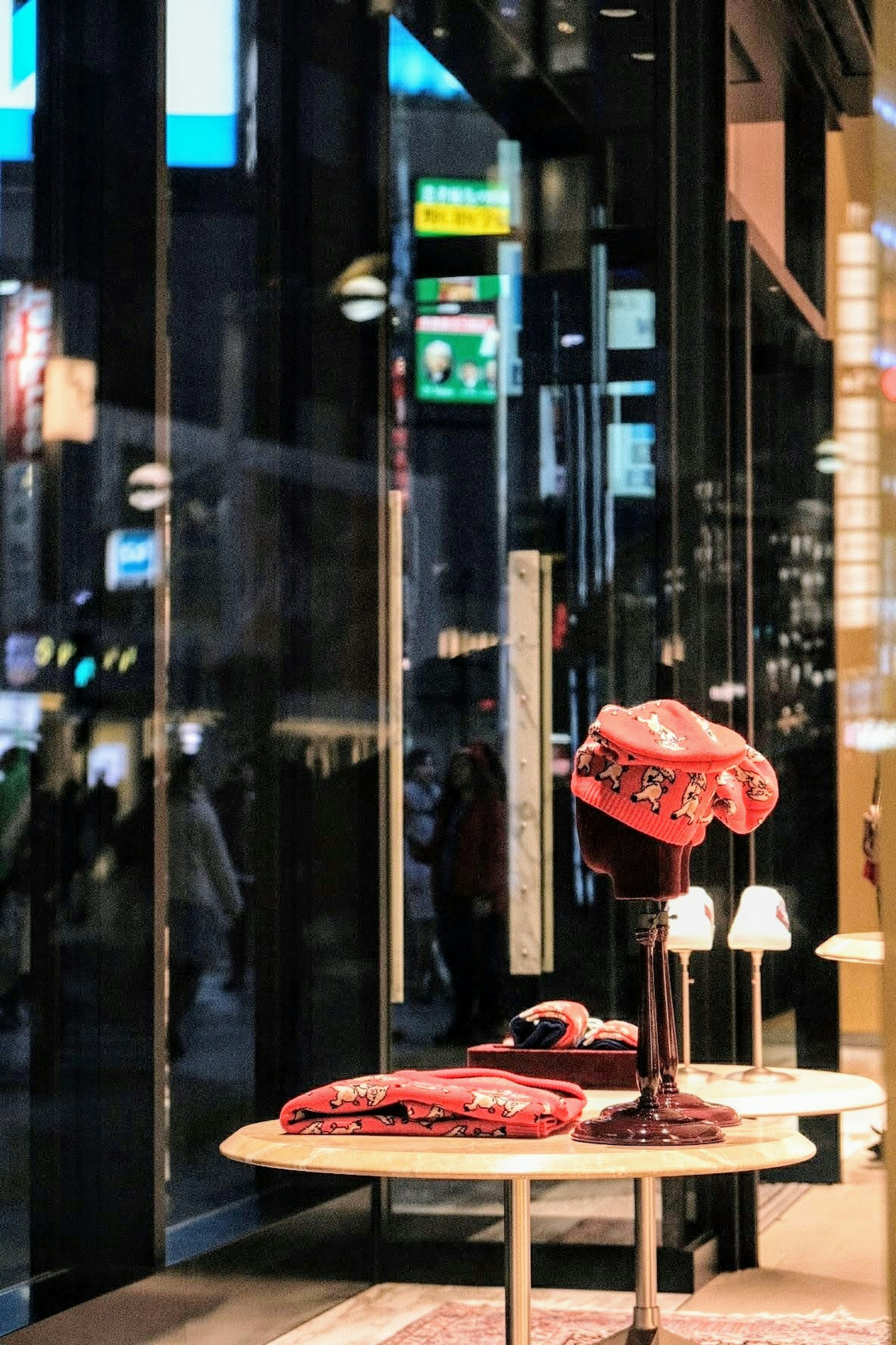 Sombrero rojo y artículos de tela exhibidos en una vitrina de tienda